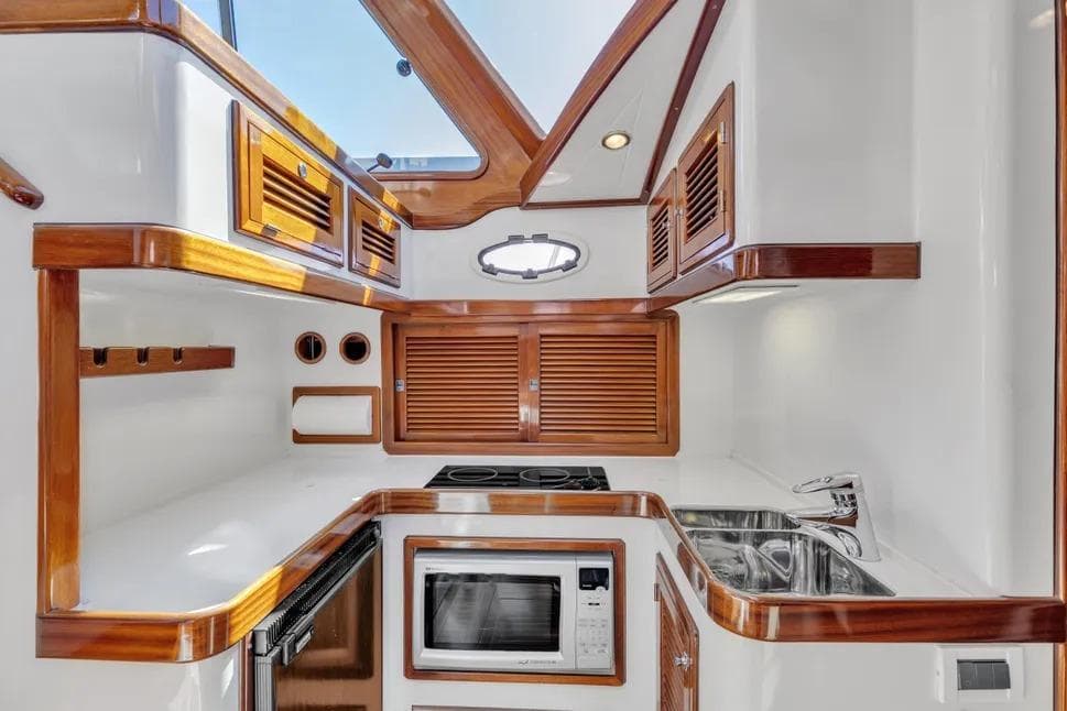 Luxurious kitchen interior of 2007 Gorbon Custom Downeast 40 yacht with wood accents and modern appliances.