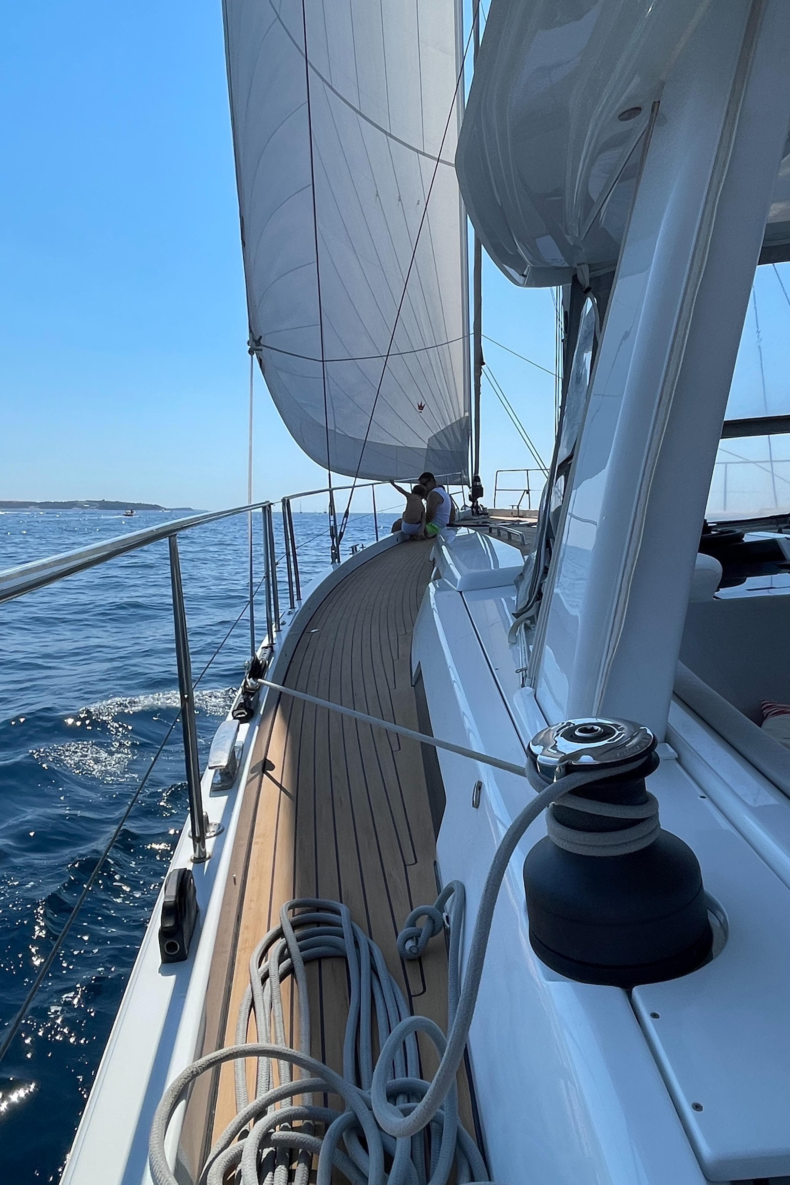 2020 Hanse 588 yacht sailing on open sea with clear blue skies.