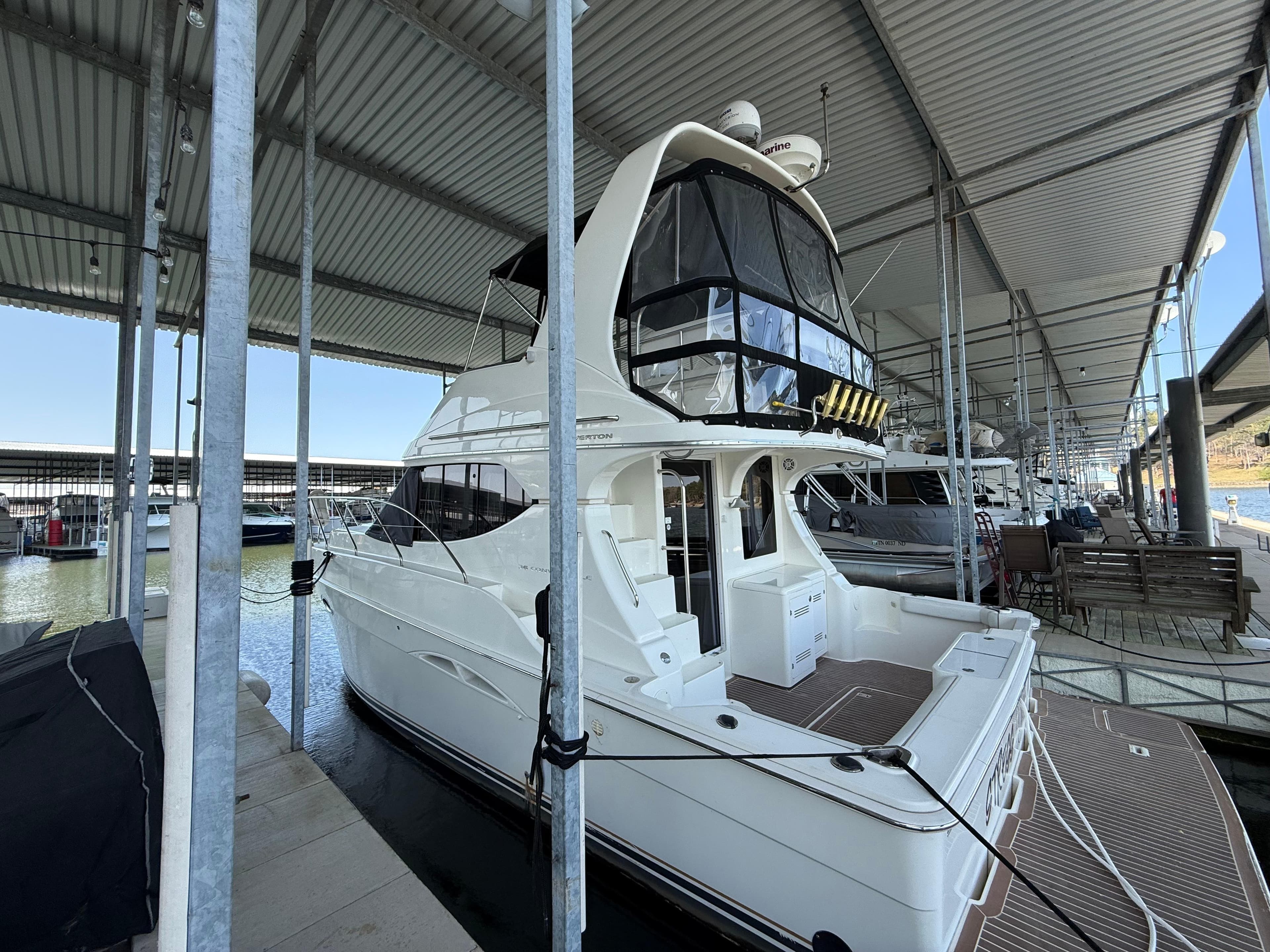 2007 Silverton 36 Convertible yacht docked under a covered marina.