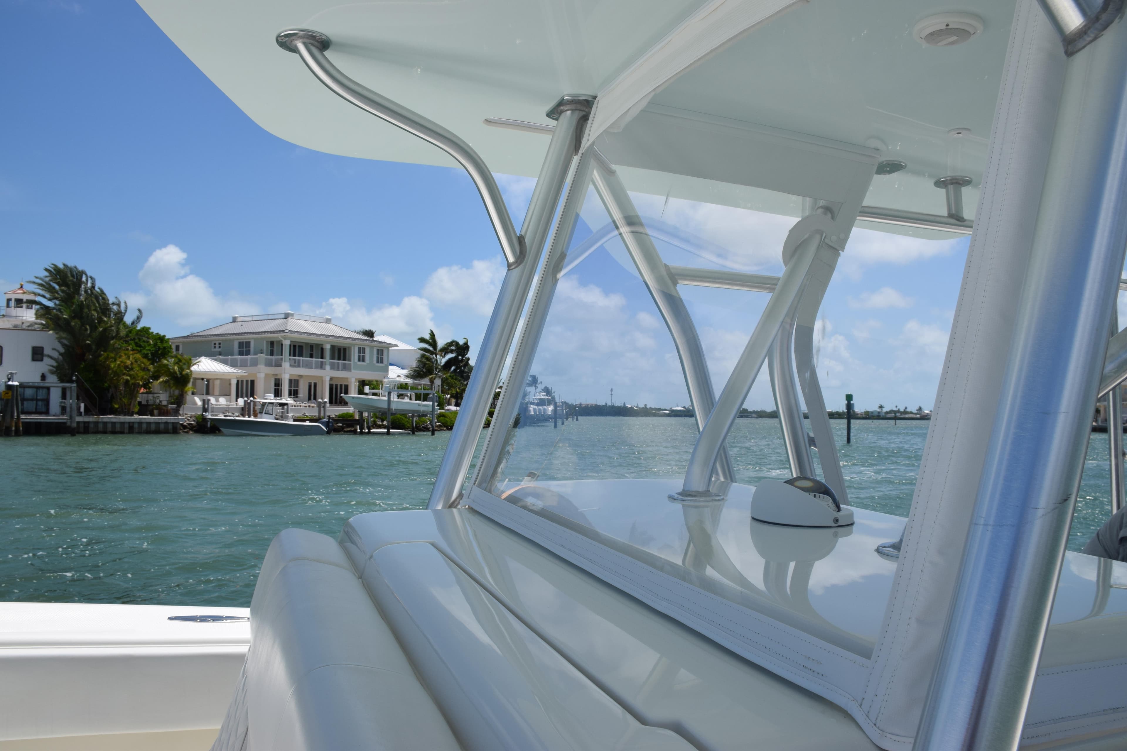 SeaVee 370z 2015 boat cruising near waterfront homes on a sunny day.