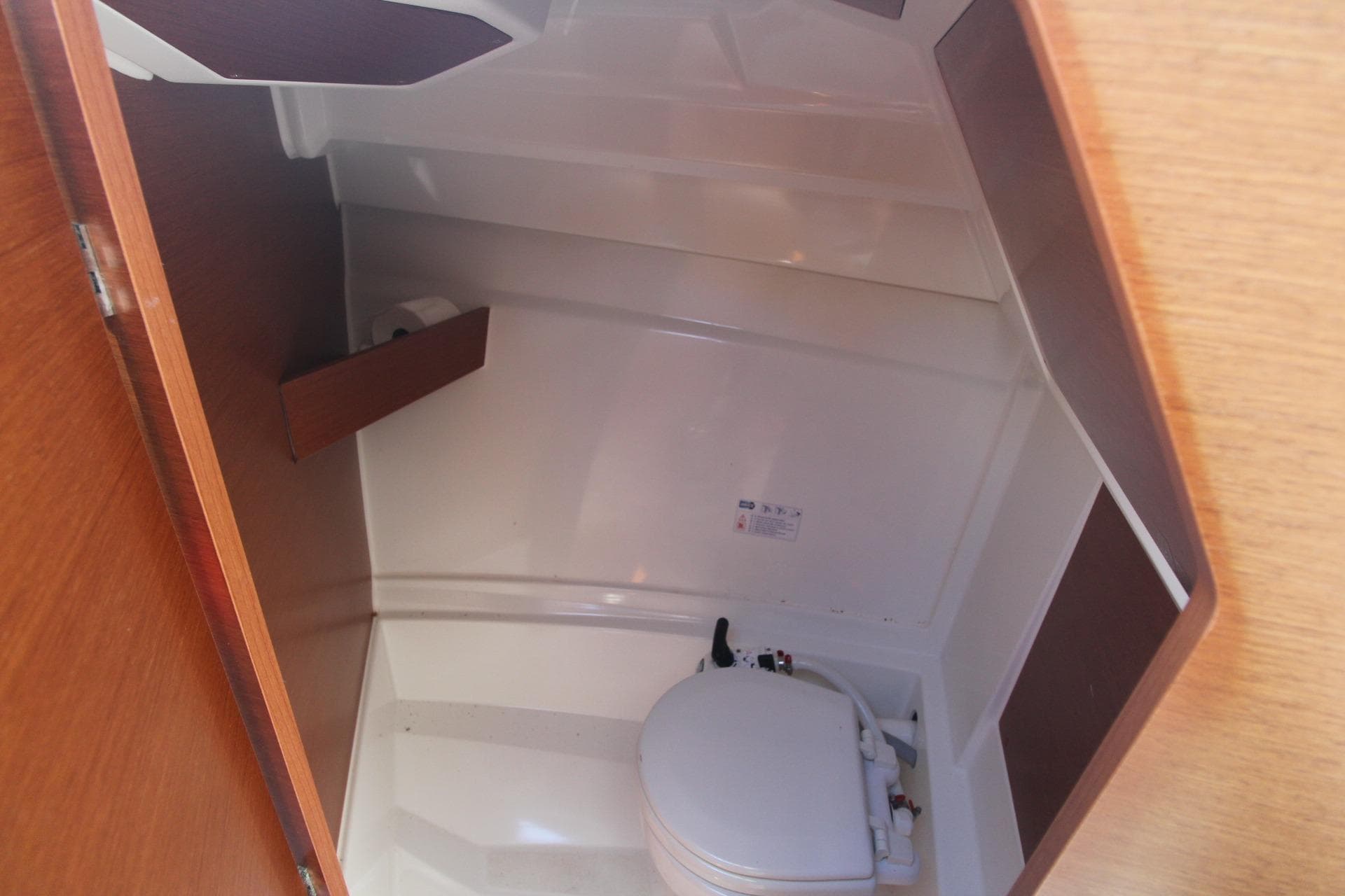 2017 Jeanneau NC Sport 695 boat interior bathroom with compact toilet.