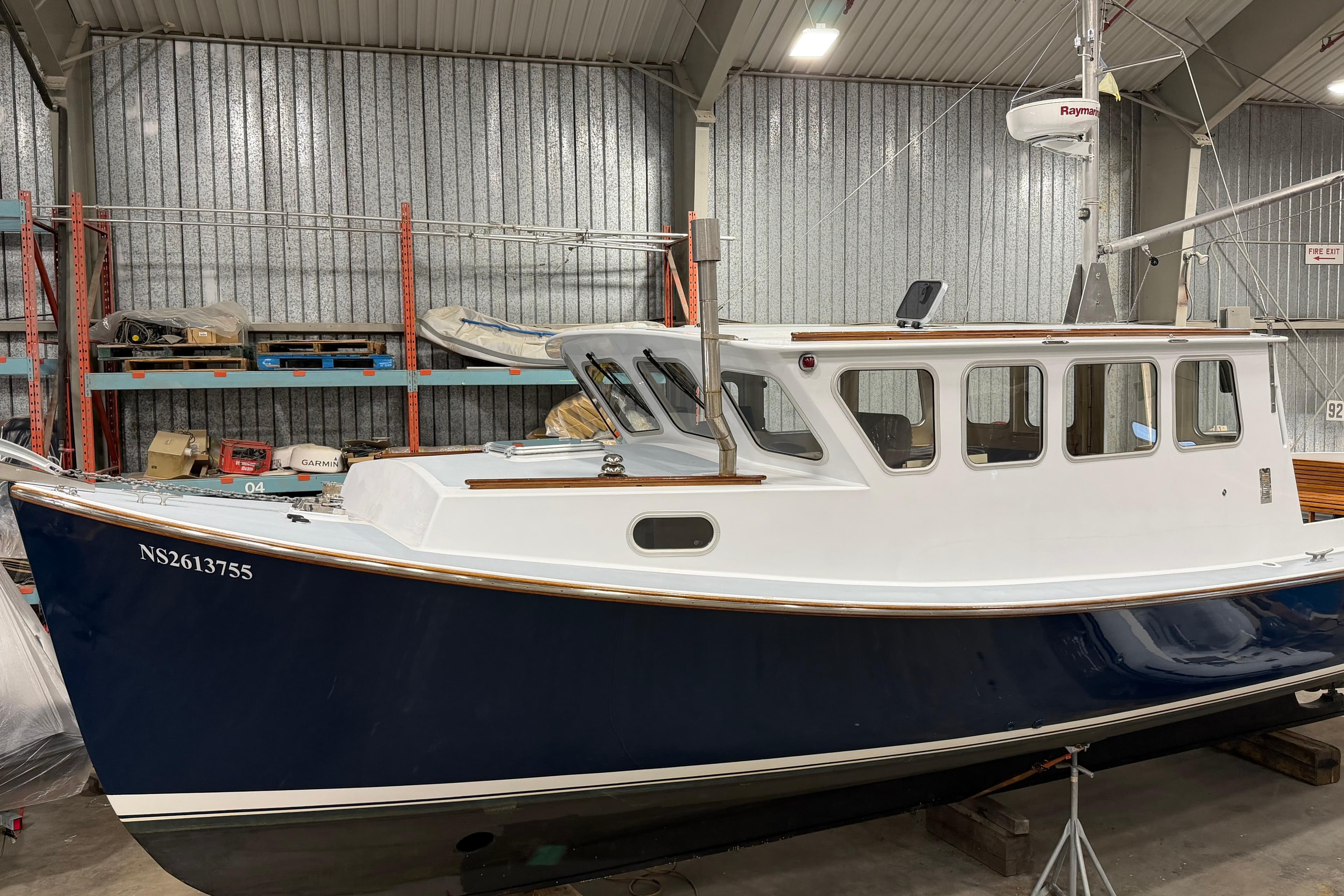 2022 Covey Island 38 Lobster Yacht in a storage facility, showcasing sleek design and craftsmanship.
