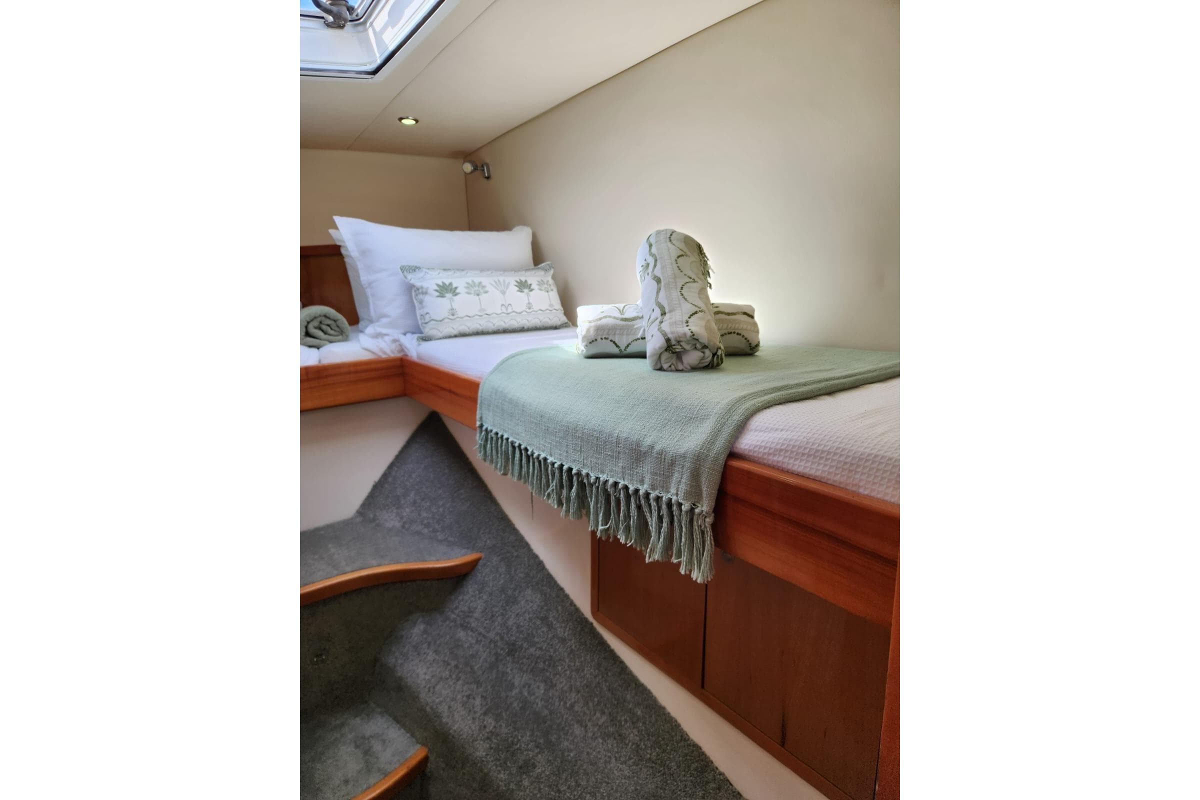 Cozy cabin interior of 2010 Montebello 12.5 Powercat with elegant bedding and soft lighting.