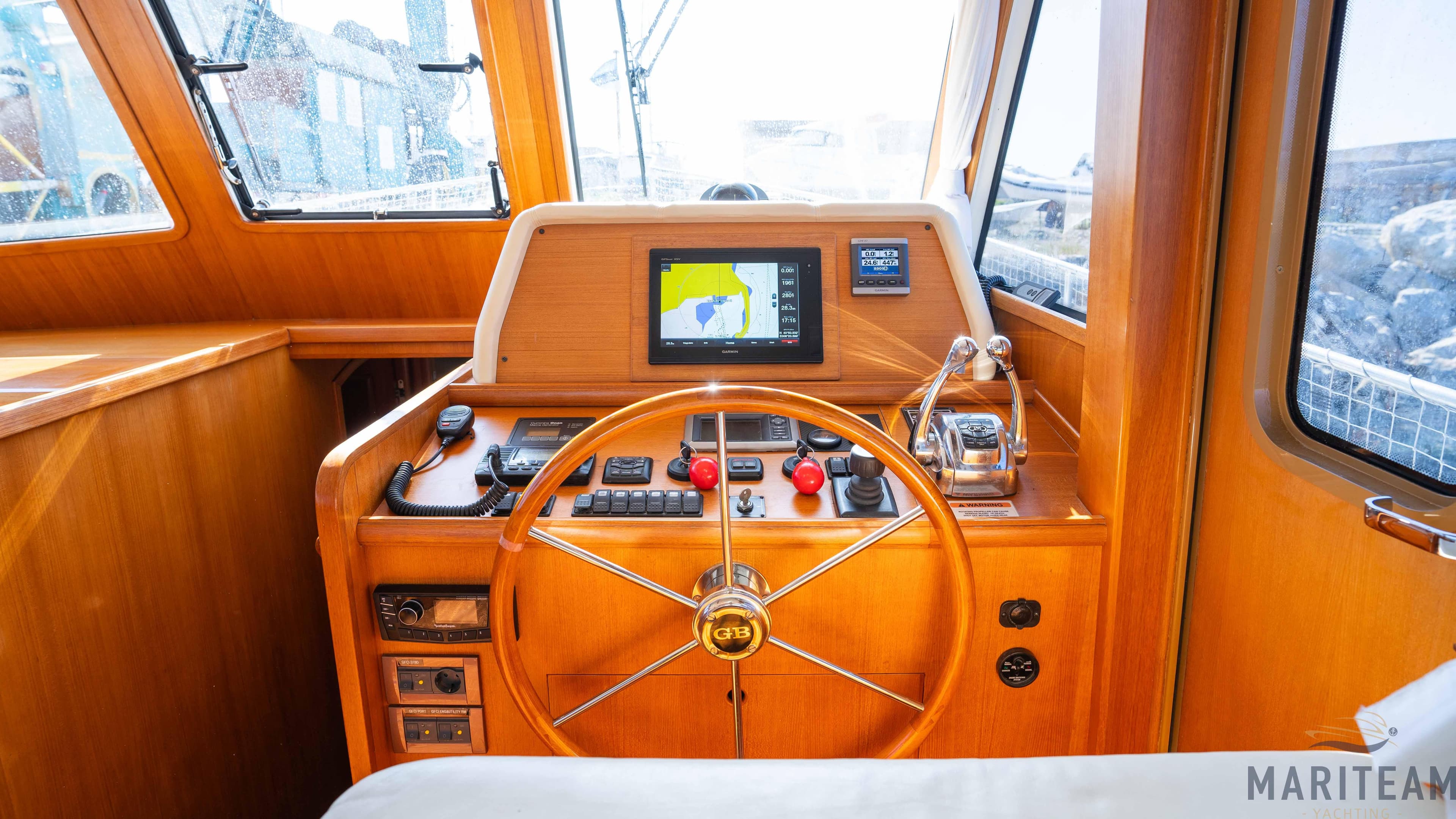Pilothouse of 2011 Grand Banks 41 Heritage EU with wooden steering wheel and navigation equipment.