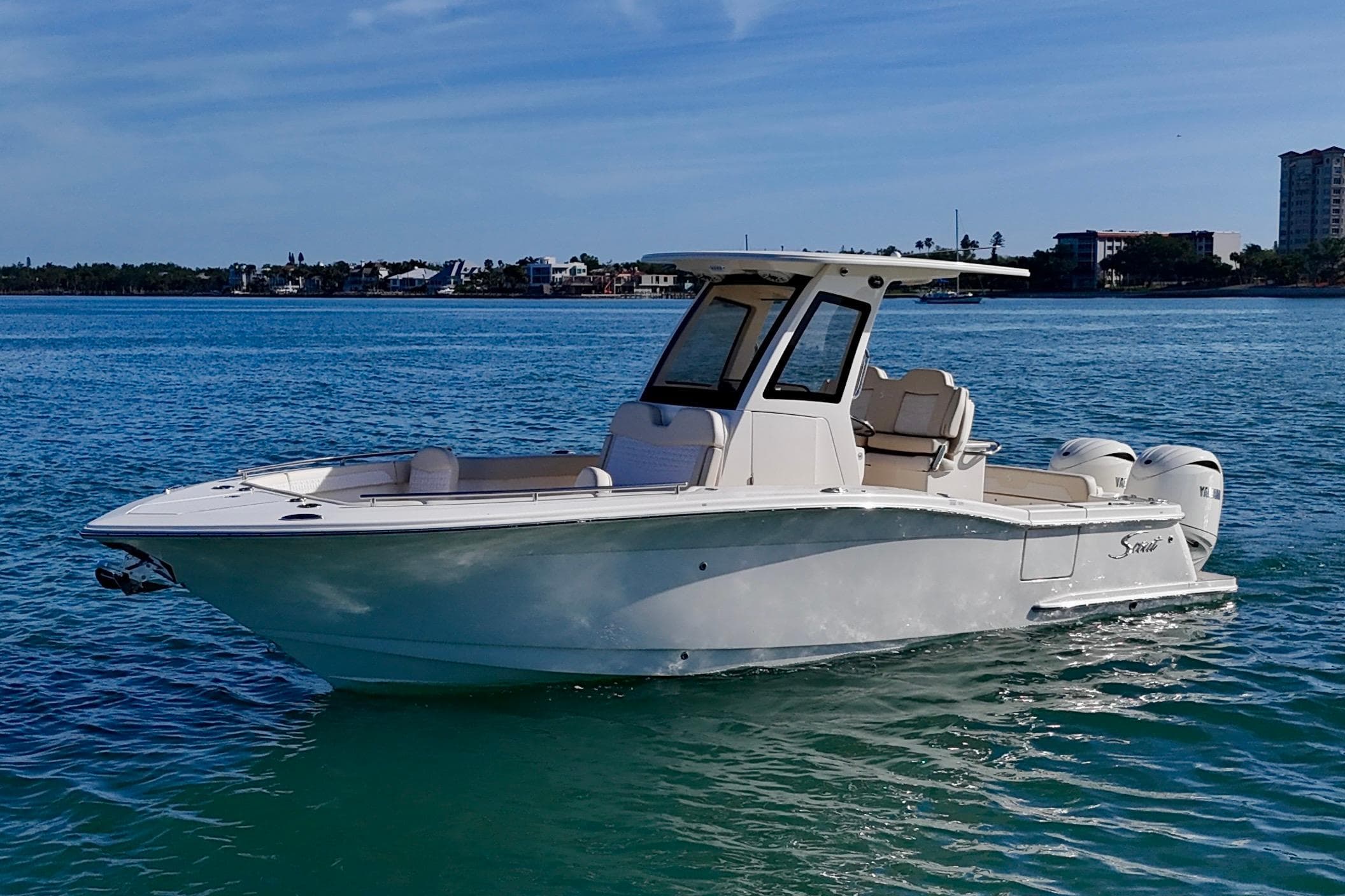 2026 Scout 260 LXF boat on clear blue water, sunny day, coastal background.