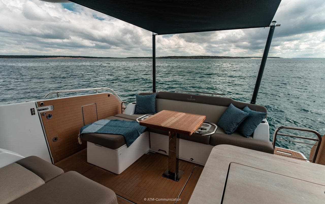 2026 Wellcraft 44 Explorer yacht interior with ocean view, featuring seating and table.