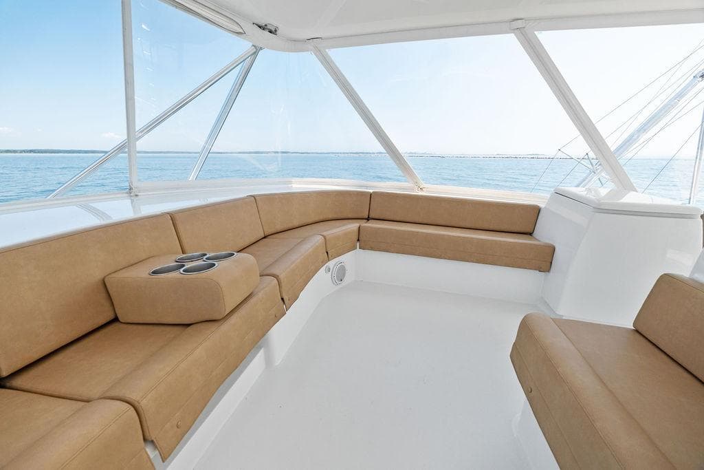Luxurious seating area on a 2006 Hatteras 68 Convertible yacht with ocean view.
