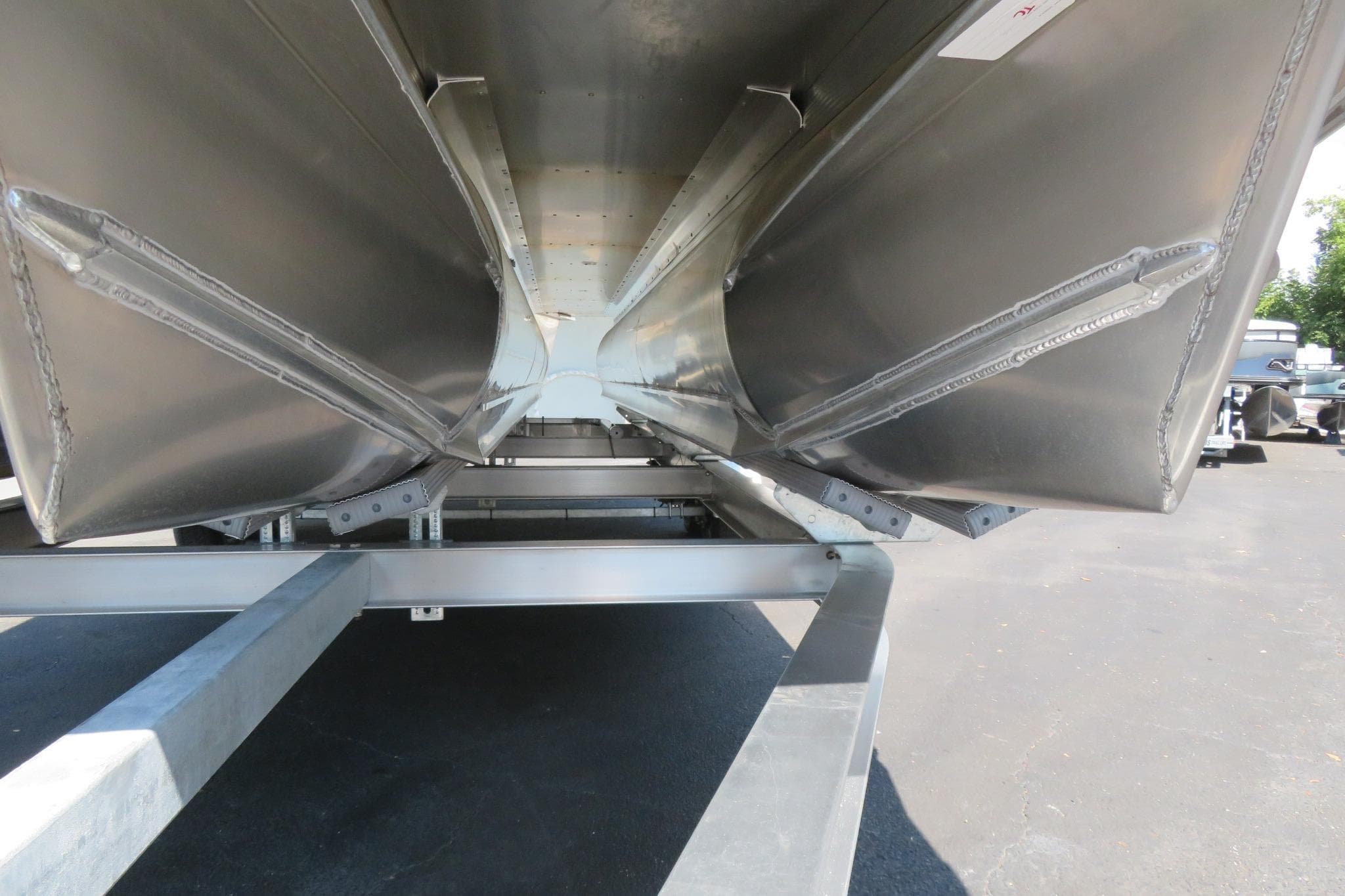 Underneath view of 2026 Avalon Catalina Quad Lounge Shift pontoon boat on trailer.