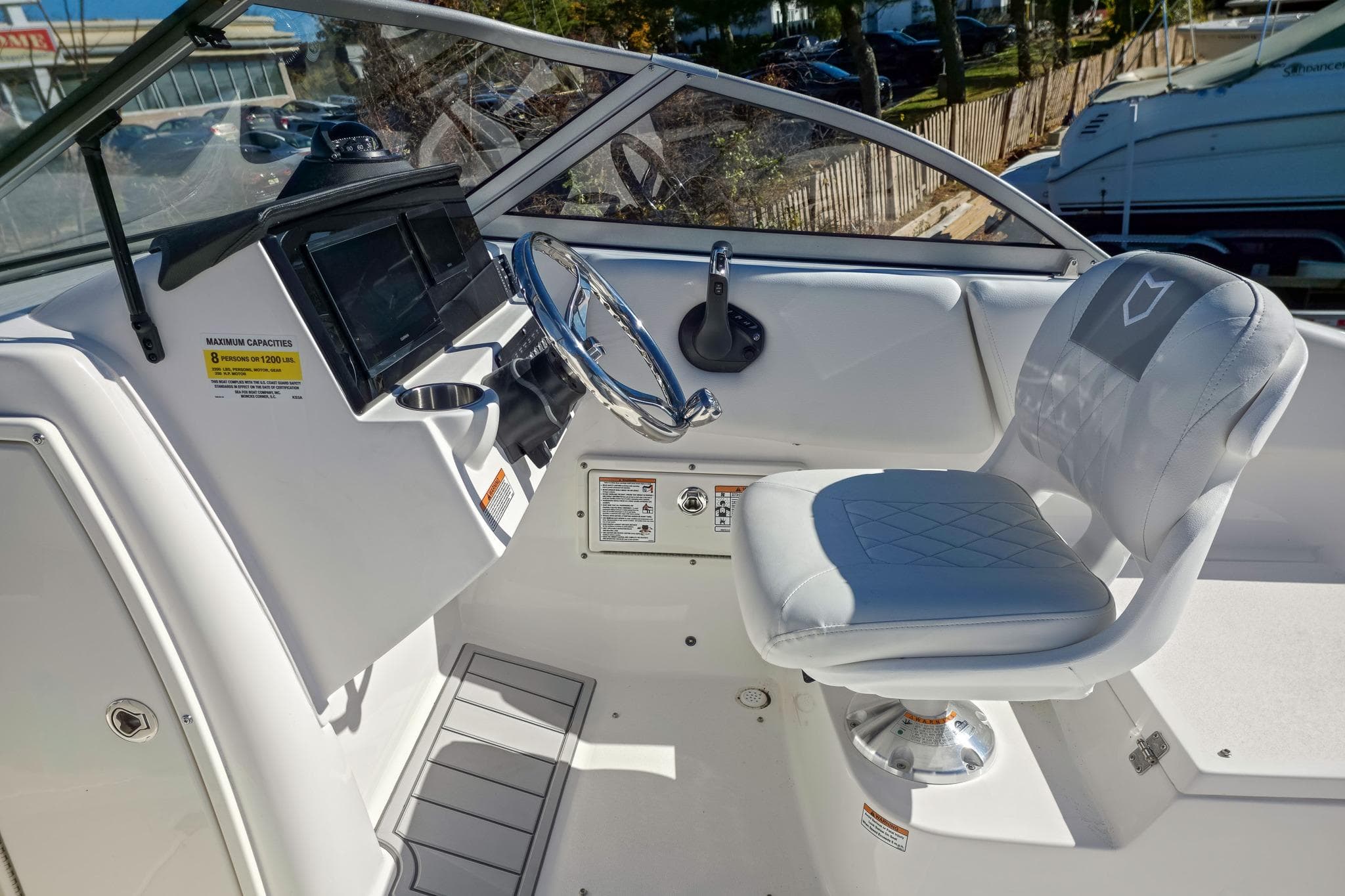 2026 Sea Fox 228 Traveler boat cockpit with steering wheel and cushioned seat.