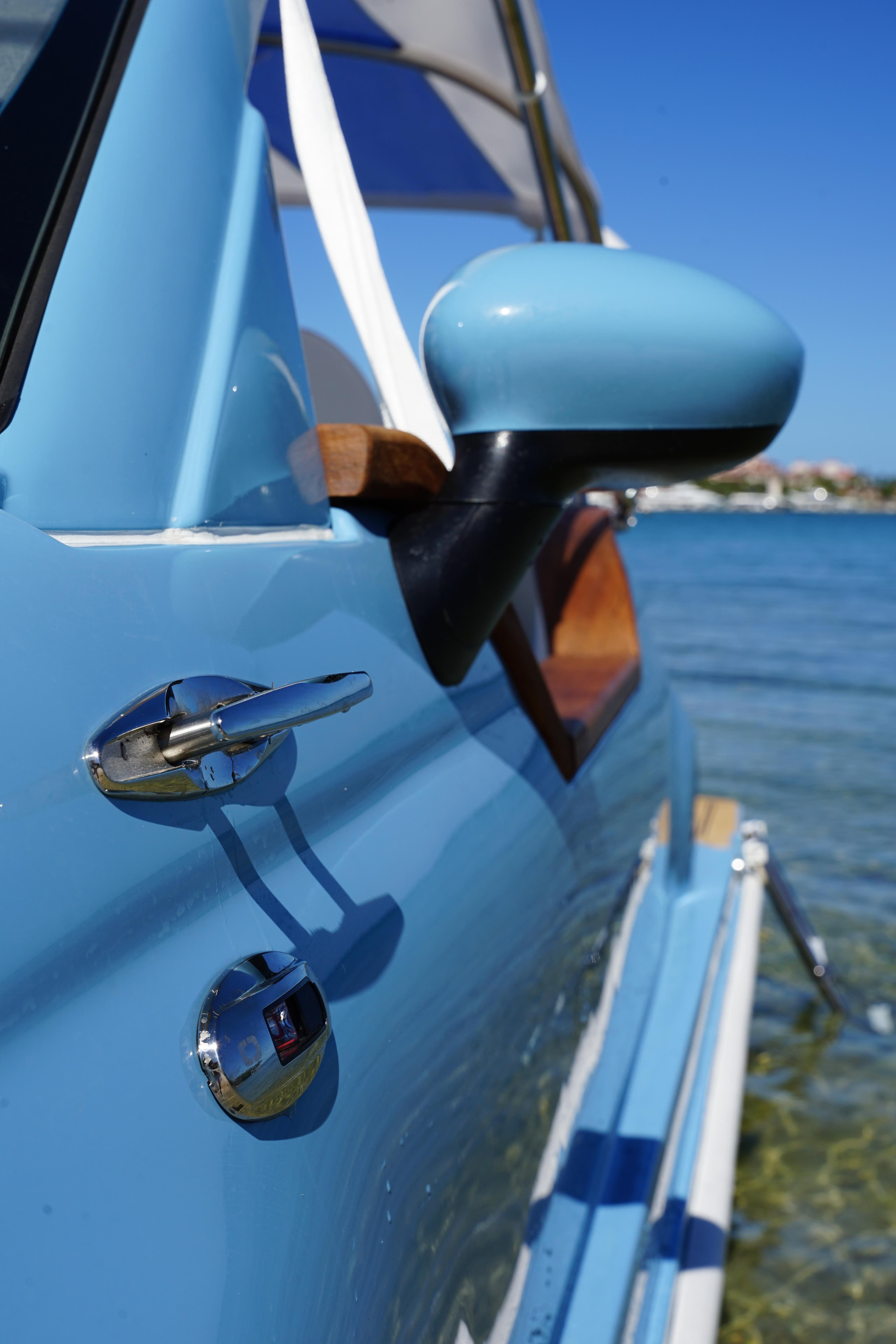 2025 Car Off-shore Fiat 500 Classic in blue, parked by the water.