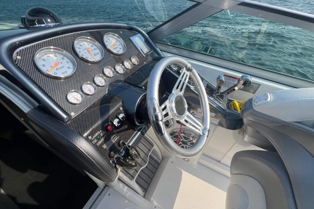 2016 Formula 353 FASTech boat dashboard with gauges and steering wheel, overlooking water.