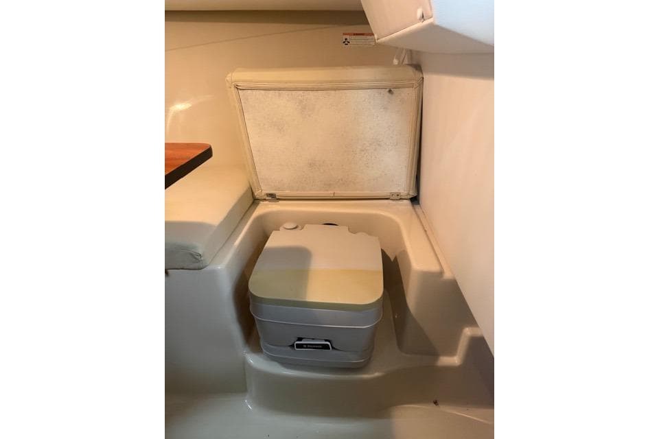 2014 Wellcraft 210 Coastal boat interior with compact portable toilet.
