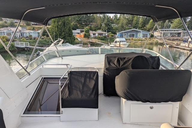 2004 Navigator 57 yacht deck with covered seating, overlooking a serene waterfront community.