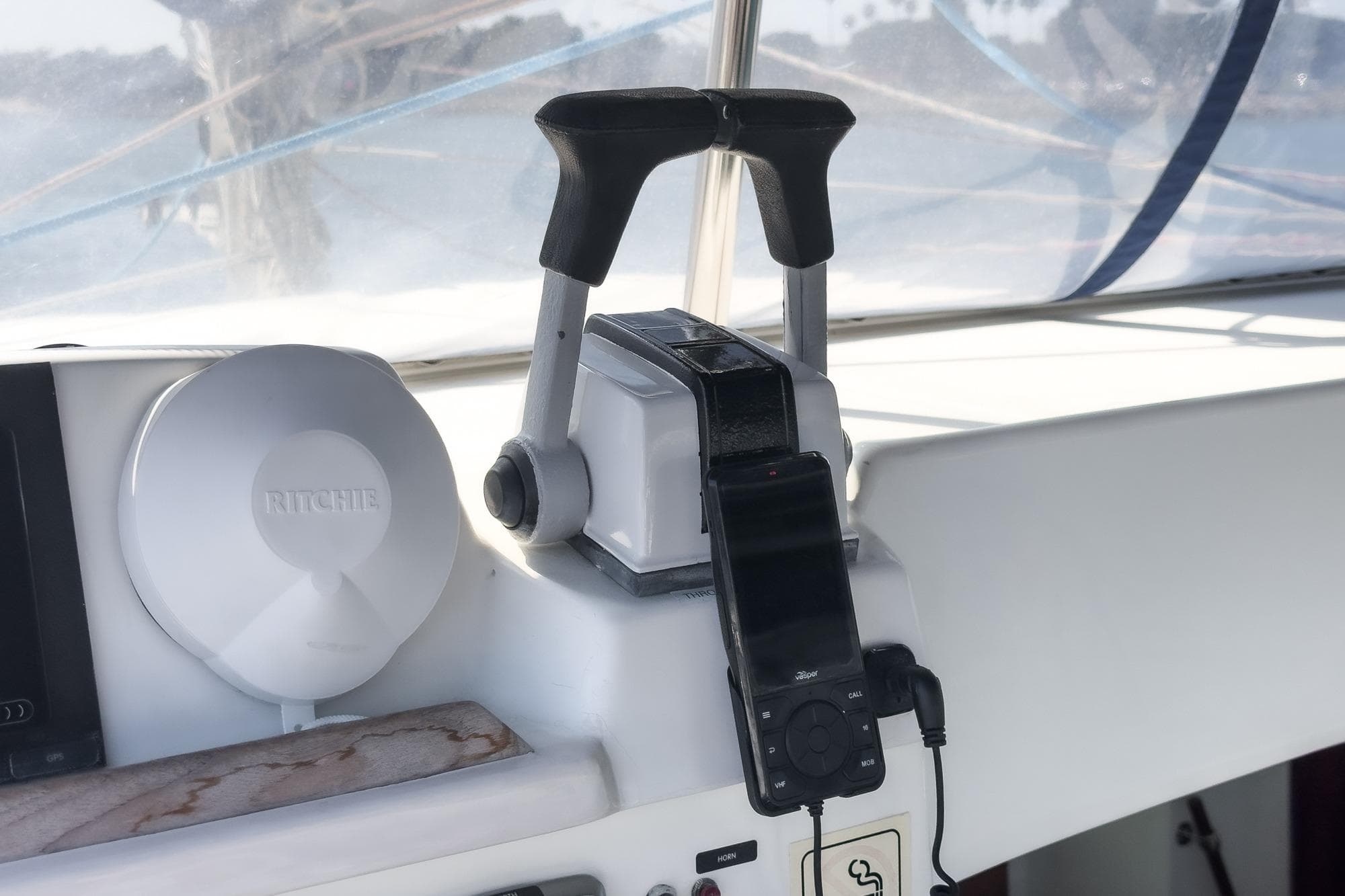 Throttle controls and compass on a 2004 Lagoon 380 catamaran cockpit.