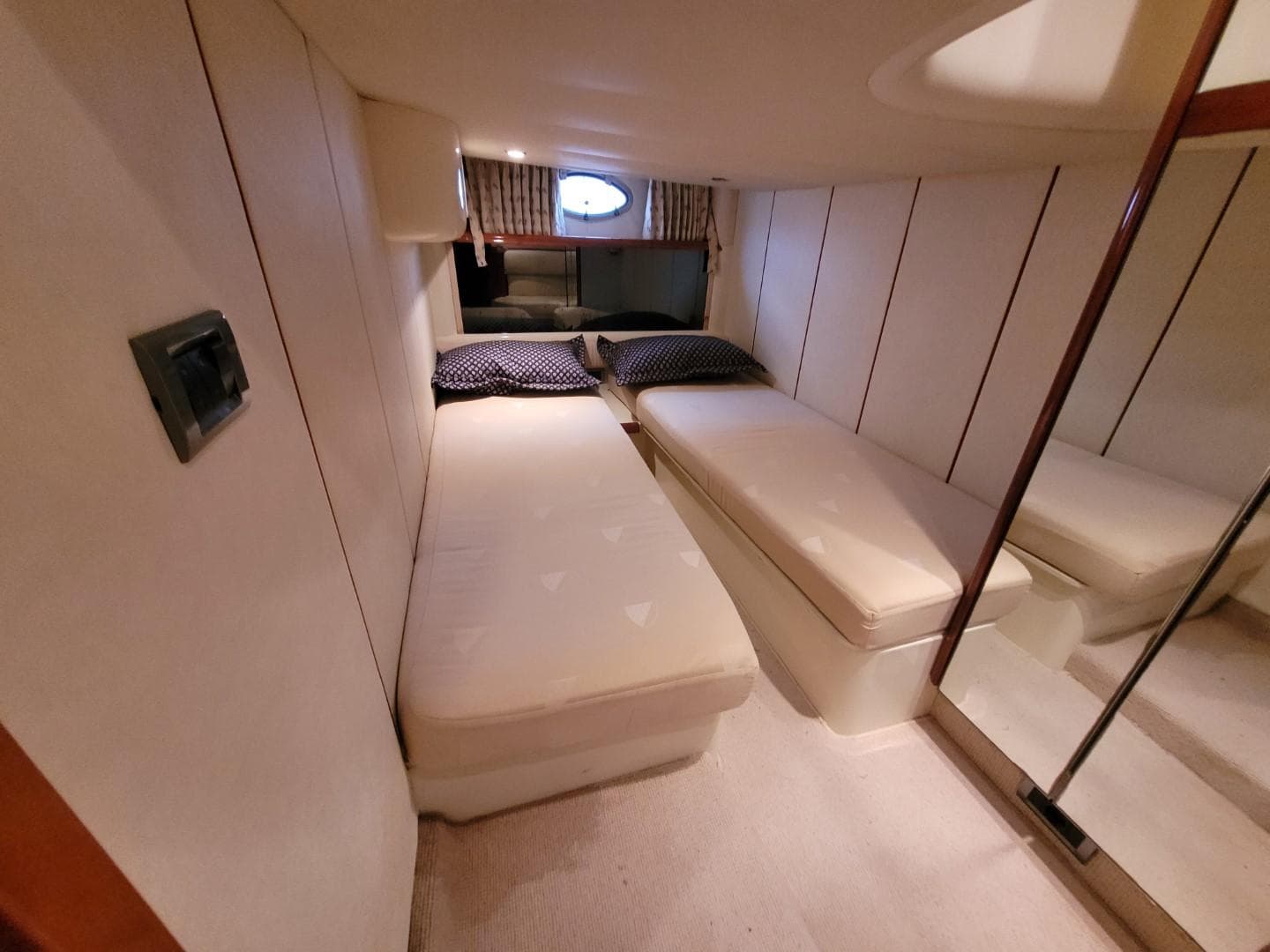 2004 Fairline Targa 43 cabin with twin beds, porthole, and mirrored closet.