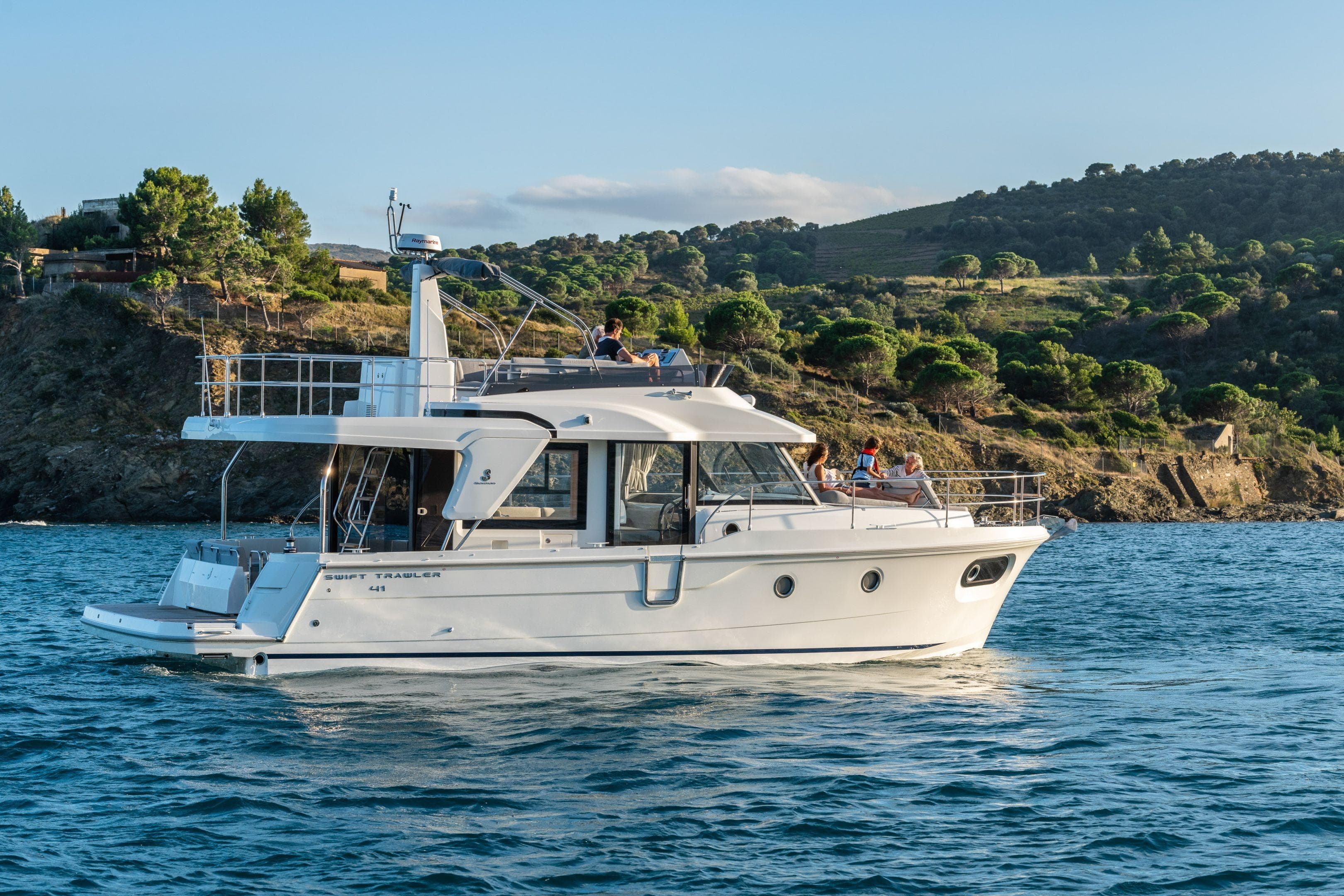 2026 Beneteau Swift Trawler 41 Fly cruising near scenic coastline.