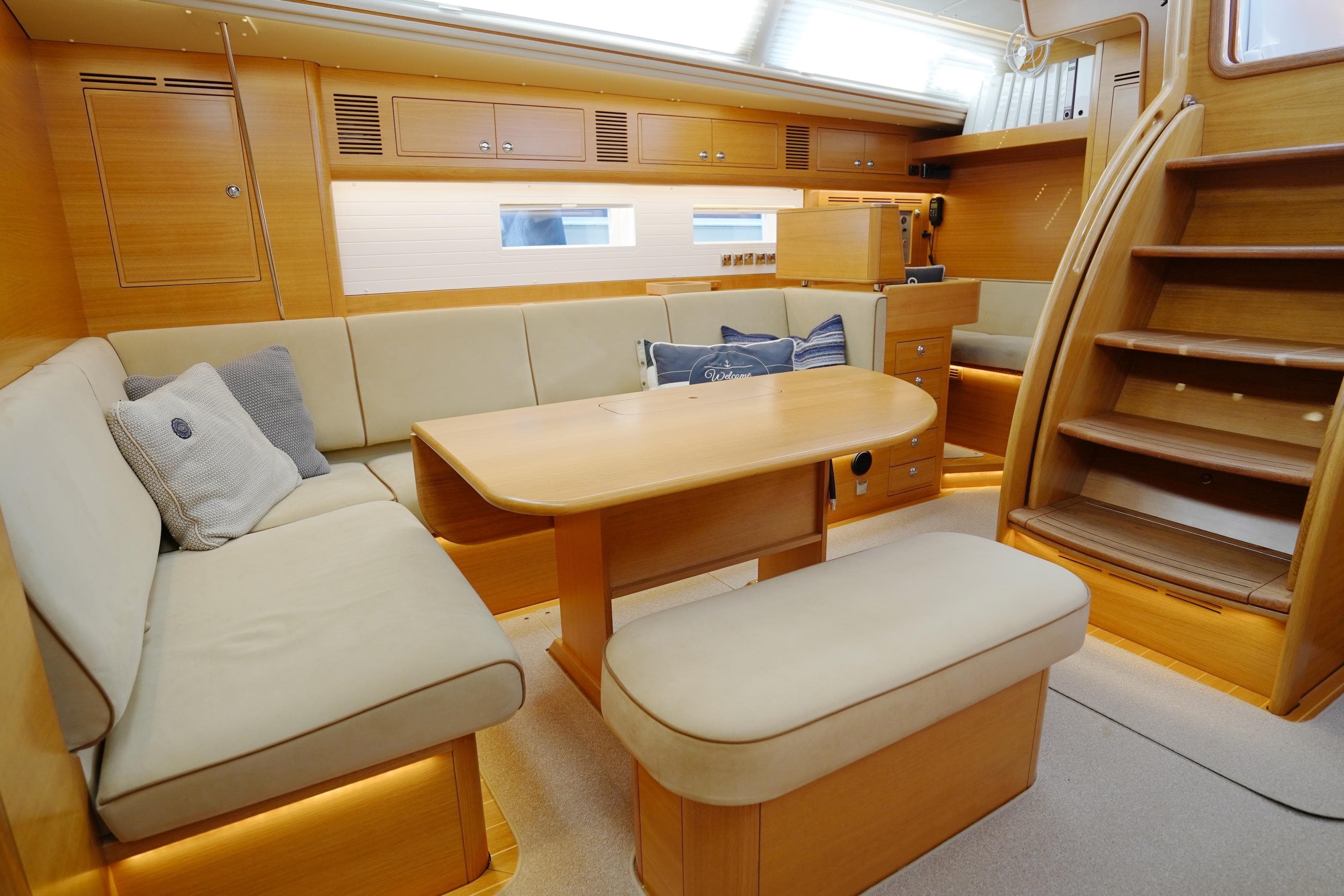 Luxurious interior of 2022 Hallberg-Rassy 57 yacht with elegant seating and wooden finishes.