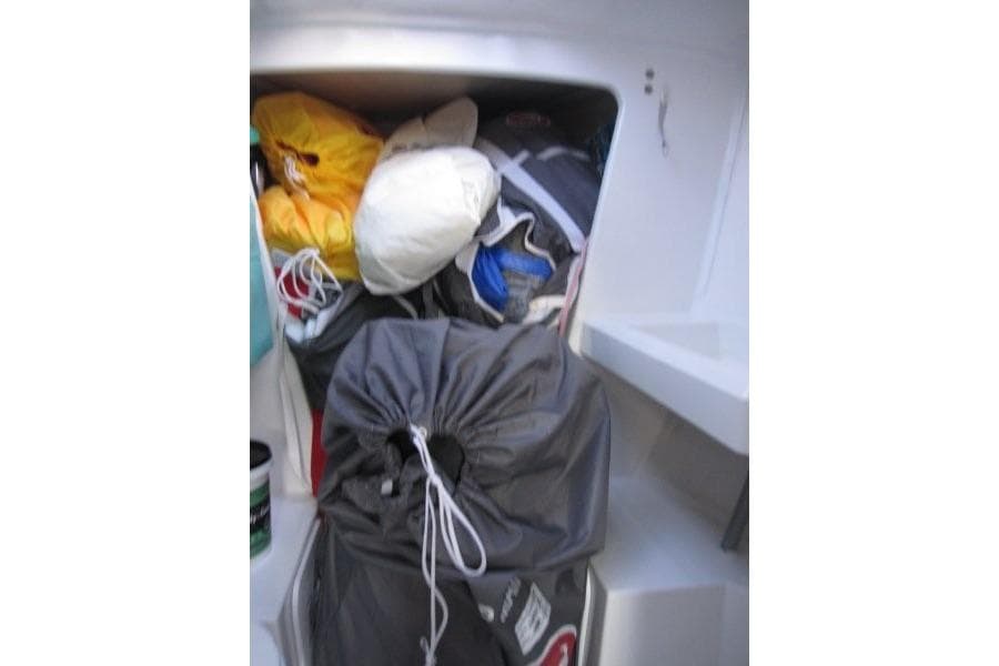 Storage compartment on a 2018 Jeanneau Sun Fast 3600 sailboat filled with gear.
