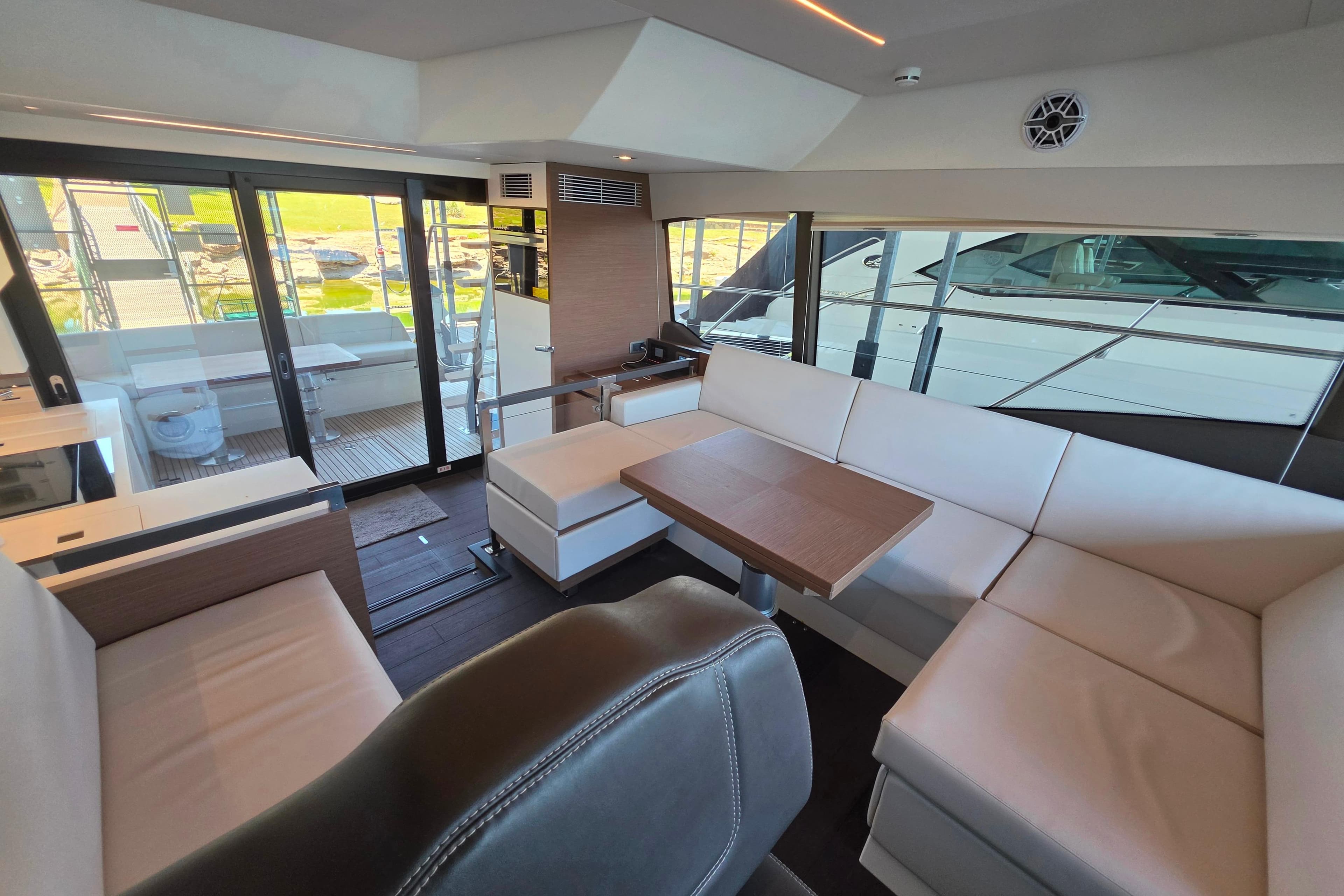 Luxurious interior of 2025 Prestige 460 yacht with modern seating and wooden table.