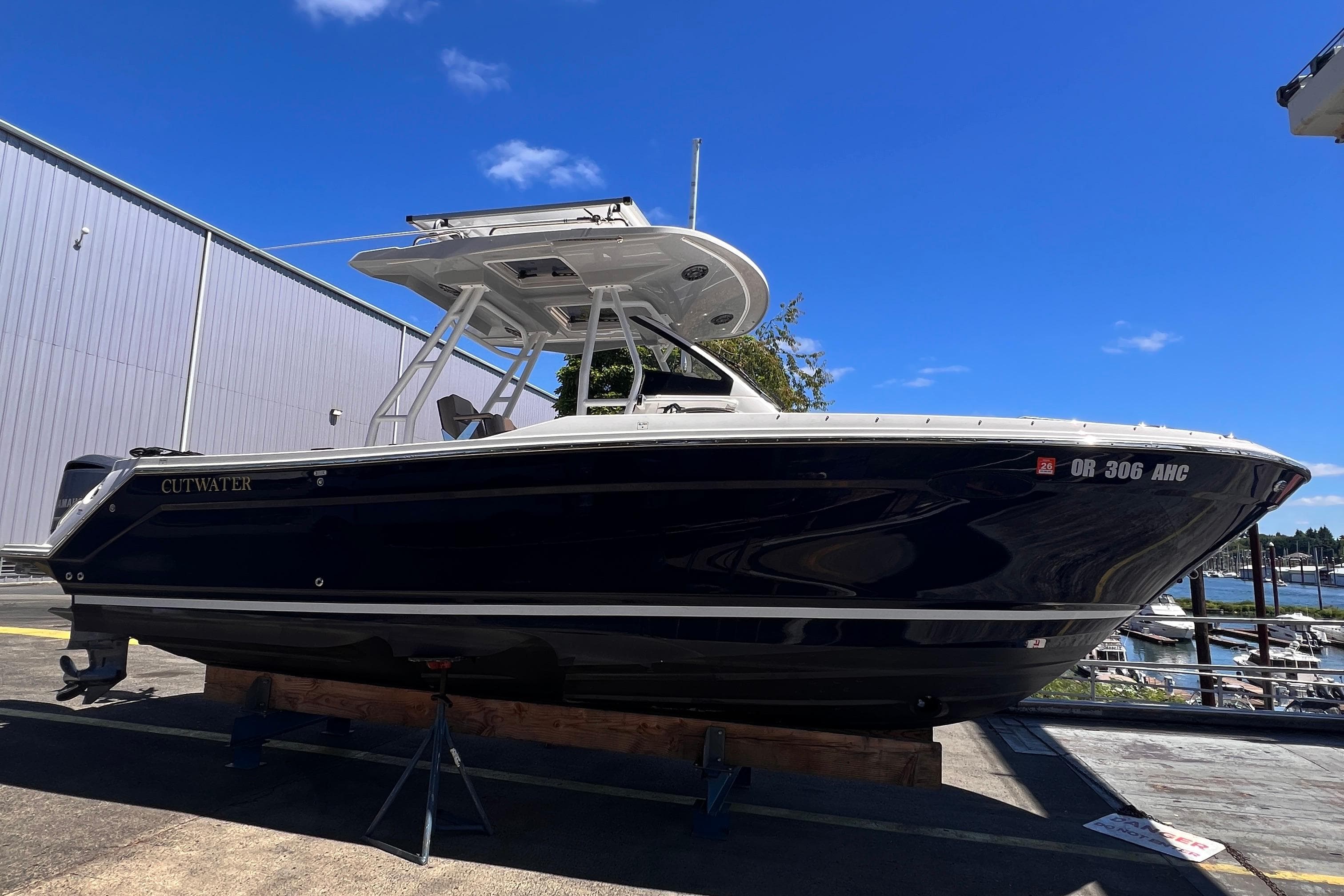 2021 Cutwater C-24 CW boat on display at a marina under clear blue skies.