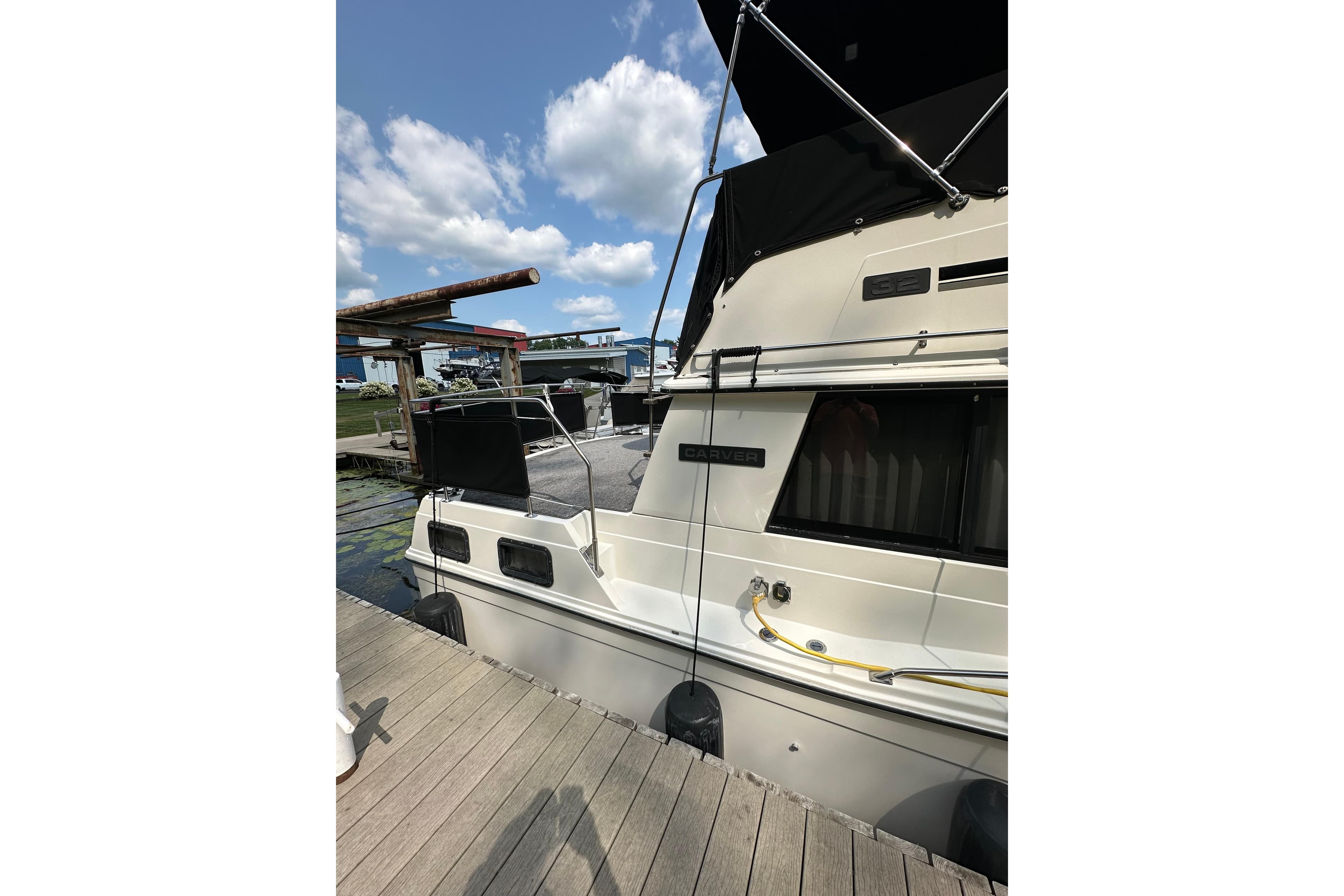 1985 Carver 3207 Aft Cabin Motor Yacht docked under blue sky.