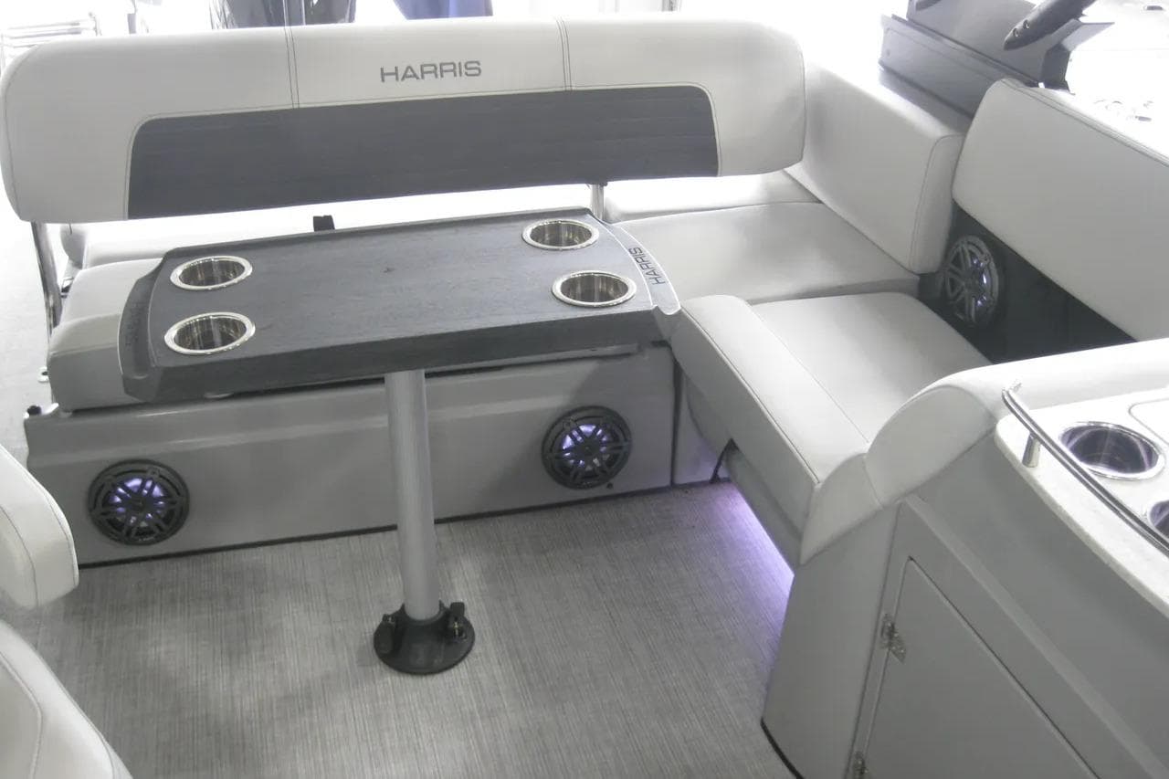 2023 Harris FloteBote 250 Solstice interior with seating and table, featuring cup holders.