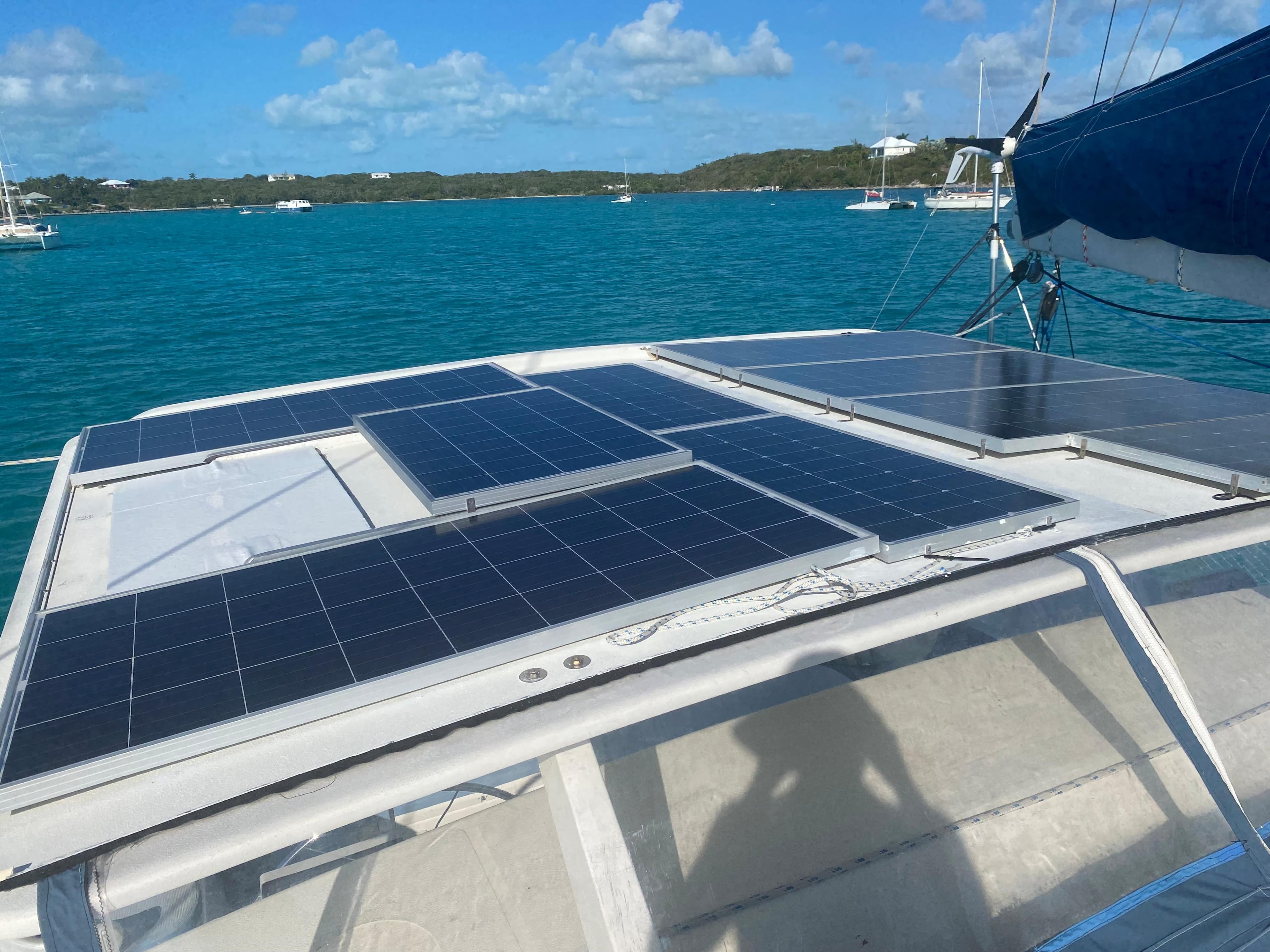Solar panels on a 1996 Voyage Mayotte catamaran in a scenic bay.