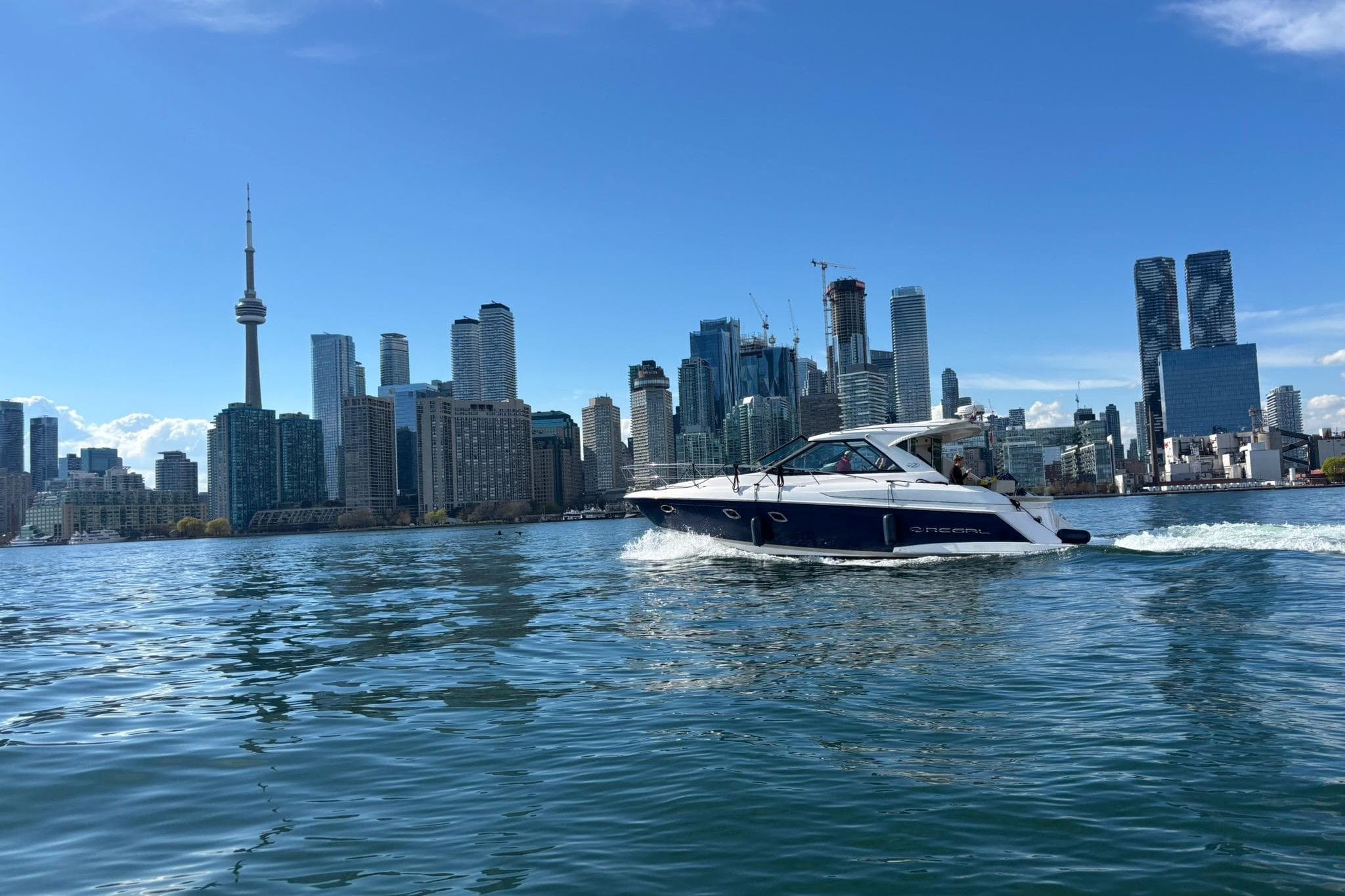 2012 Regal 42 Sport Coupe cruising near city skyline on a sunny day.