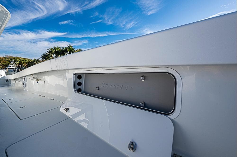 2023 Freeman 47 boat deck with storage compartment under a clear blue sky.