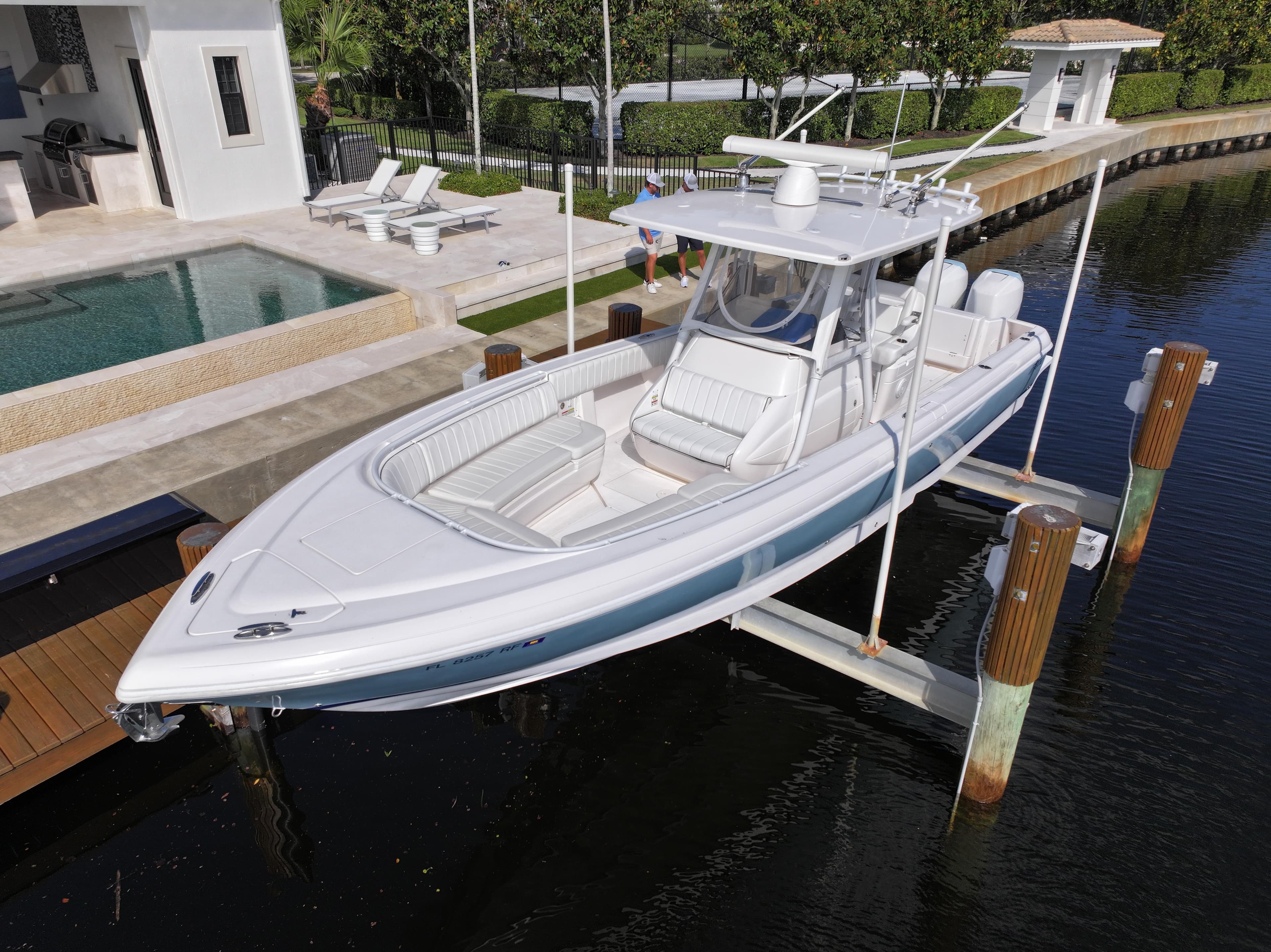 2017 Intrepid 327 boat docked near luxury waterfront home.