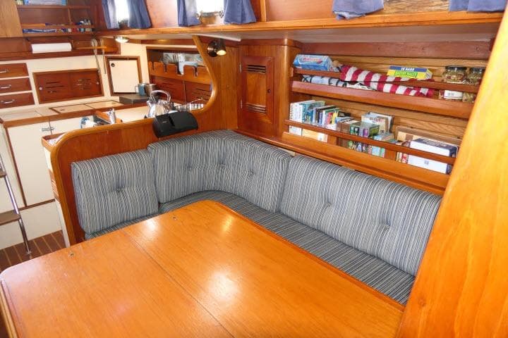 Interior of 1982 Cape Dory 36 sailboat with cozy seating and wooden cabinetry.