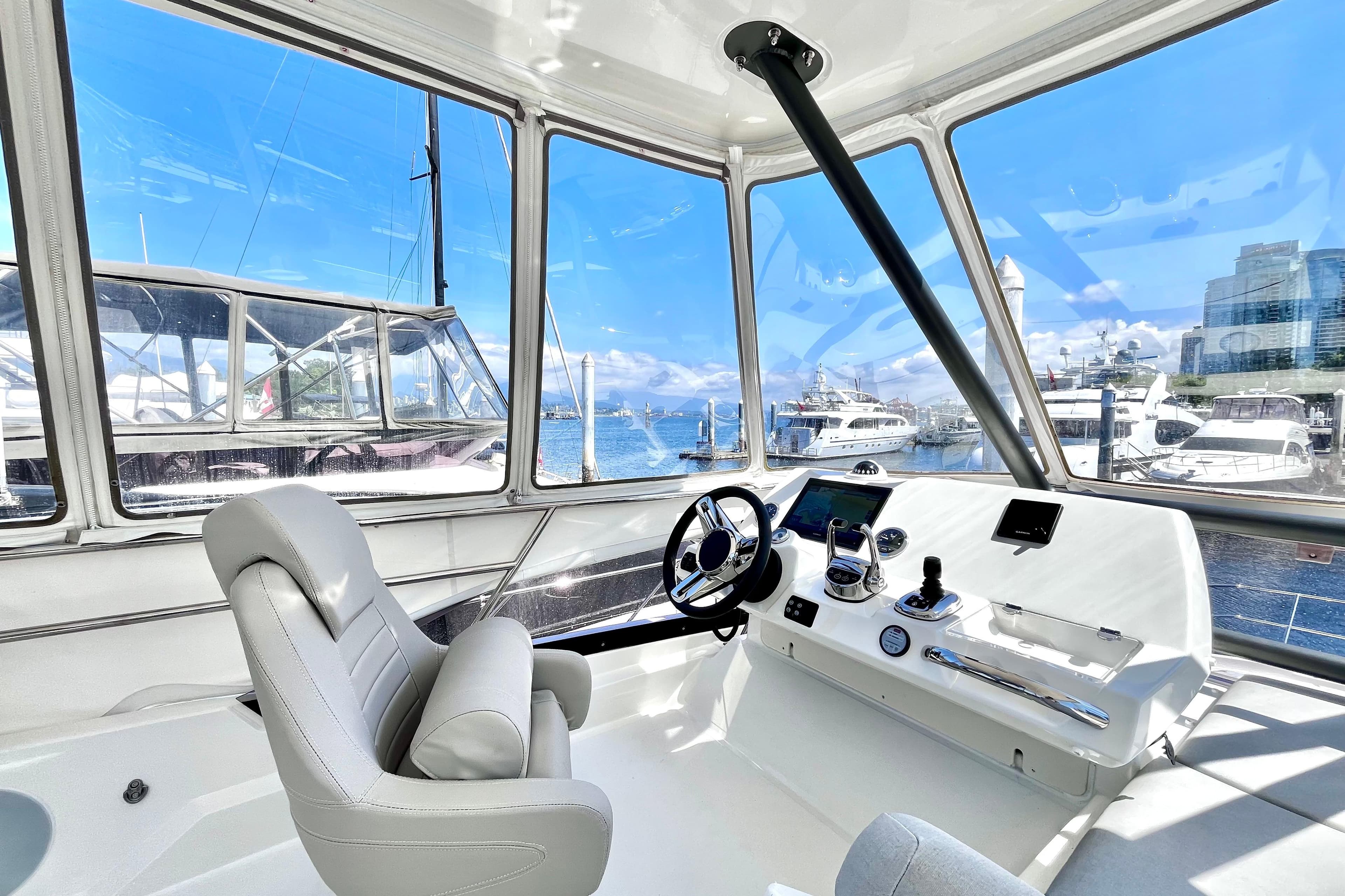 Interior view of 2023 Prestige 420 yacht cockpit with marina backdrop.