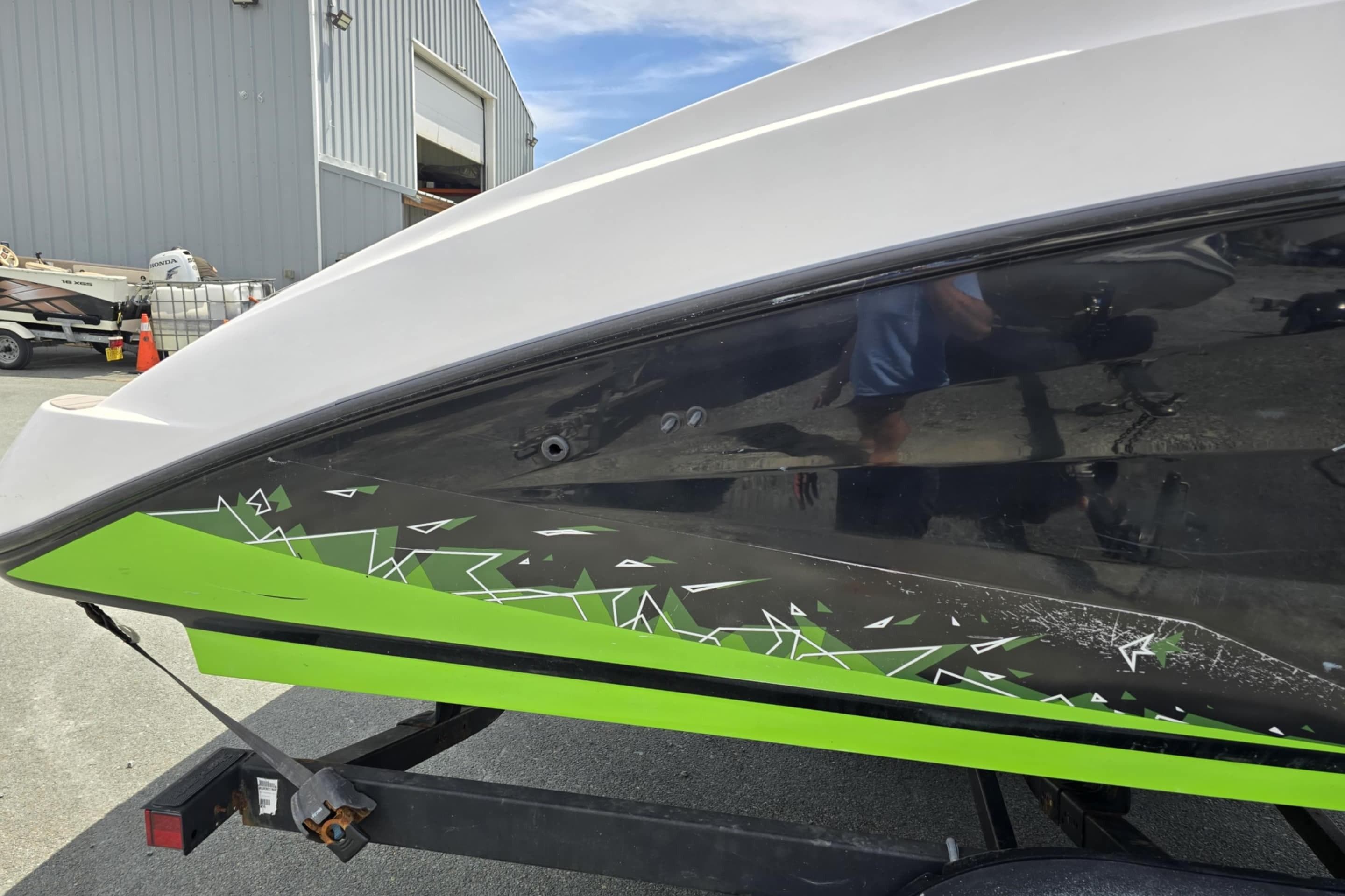2021 Yamaha AR250 boat with green and black geometric design on trailer.