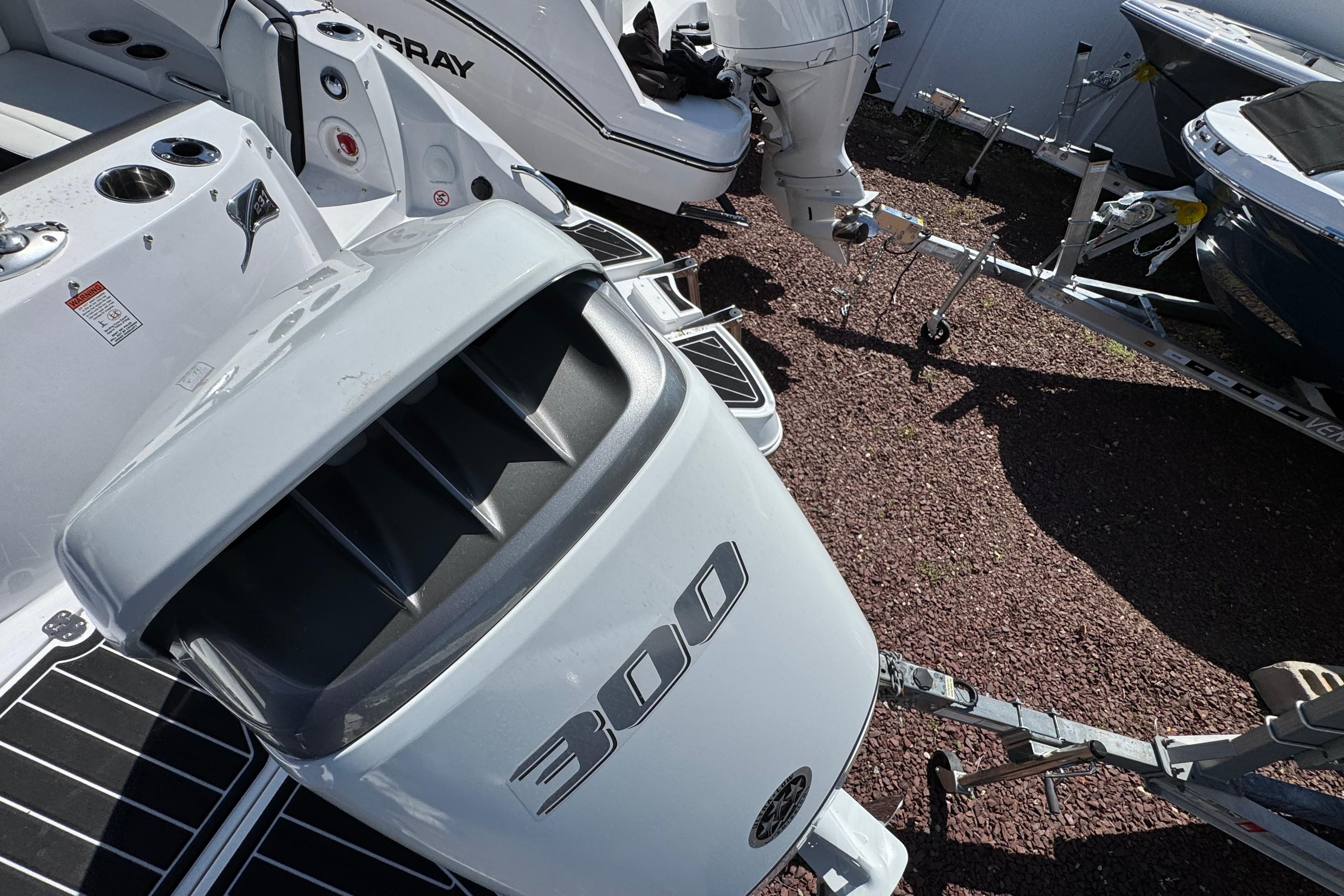 2026 Stingray 231 DC boat with powerful 300 horsepower engine, parked on gravel.