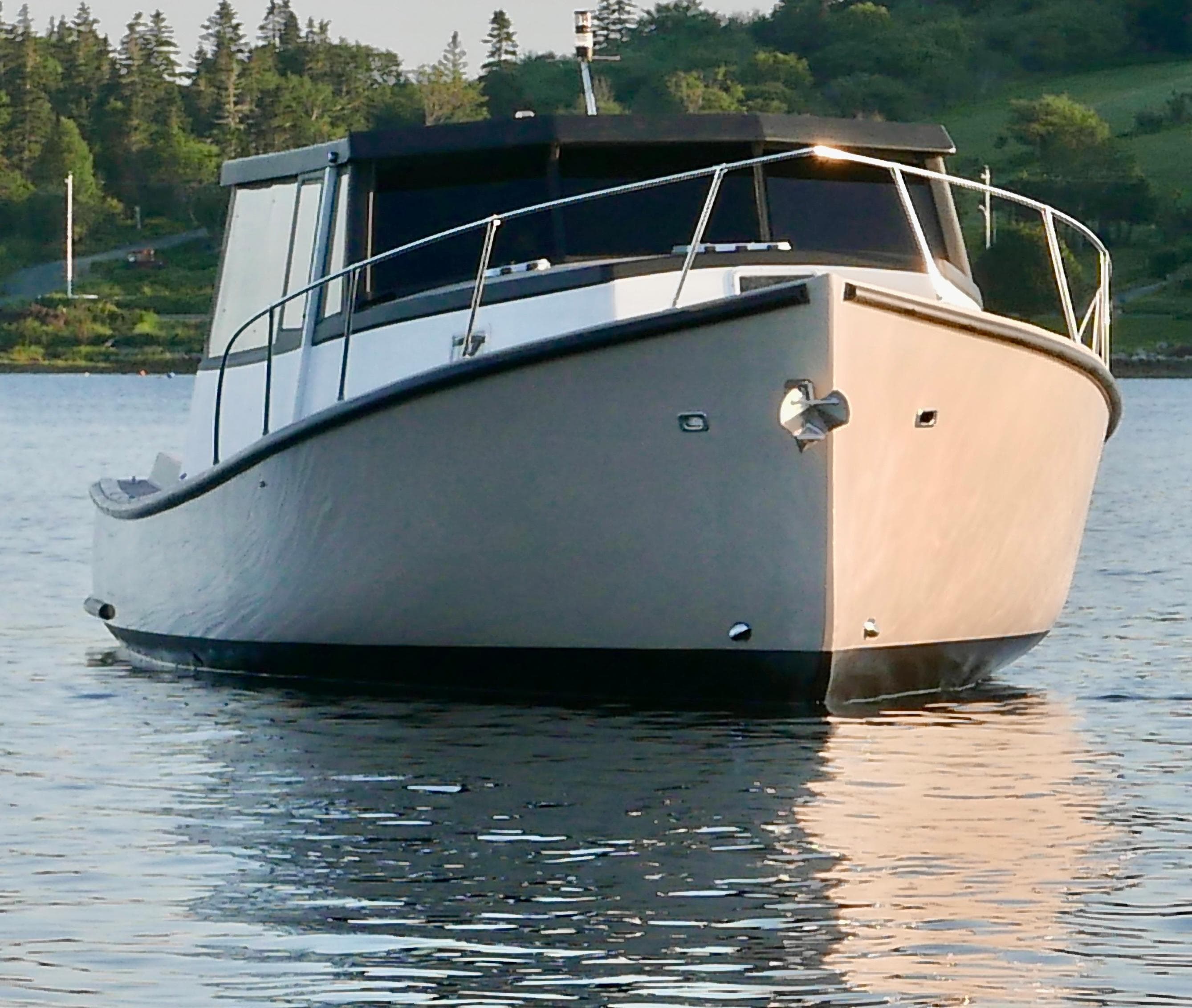 2021 Trawler Cape Island Cruisers Cape Sable on calm water, surrounded by lush greenery.