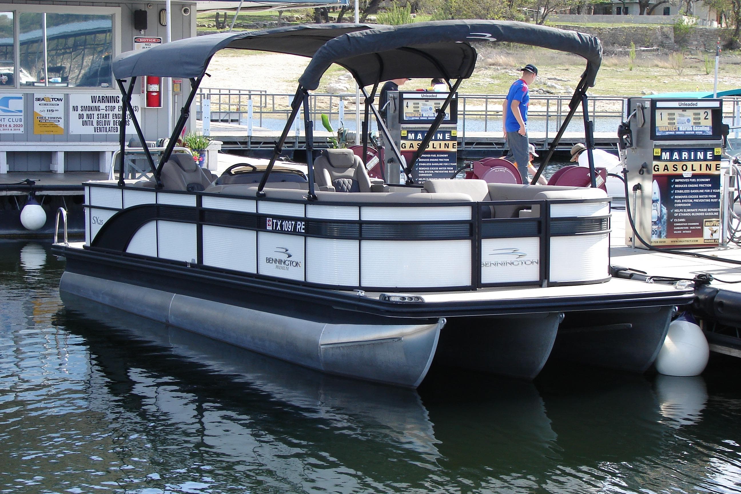2019 Bennington SX 25 SCWXP pontoon boat docked at marina with gas pumps.