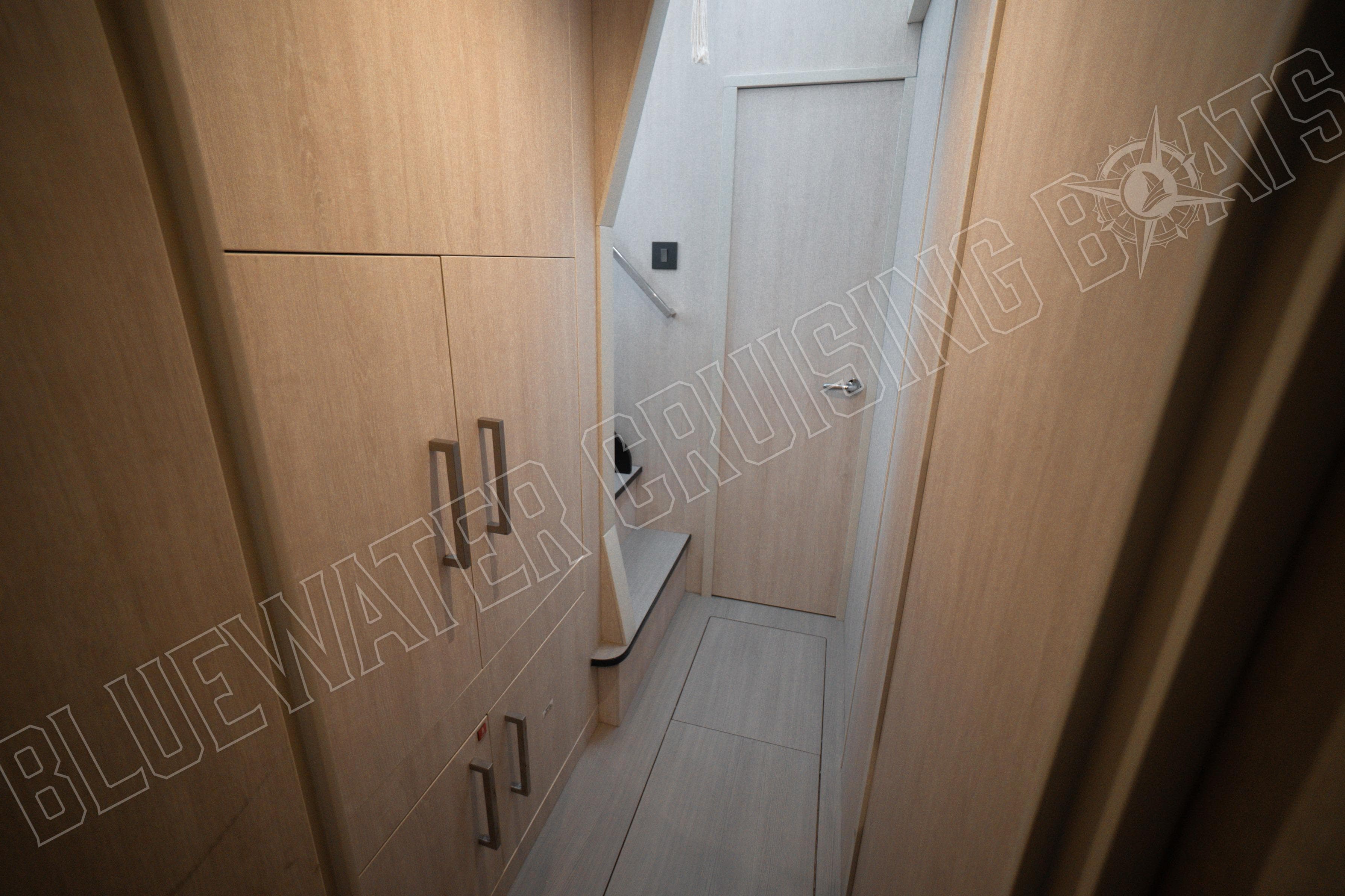 Narrow hallway inside 2020 Leopard 58 yacht with wooden cabinetry and modern design.