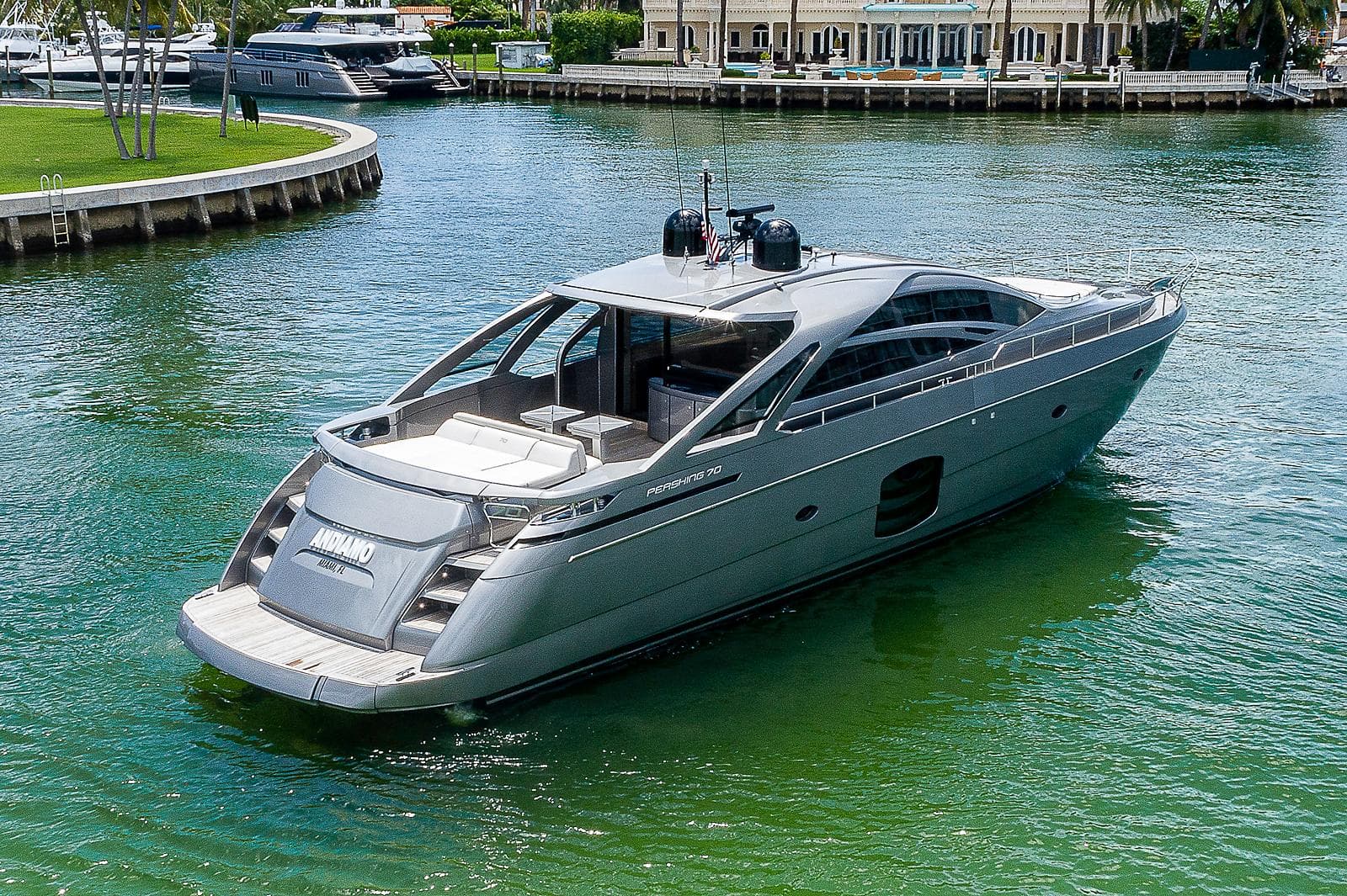 Luxurious 2015 Pershing 70 yacht cruising in a serene waterfront setting.