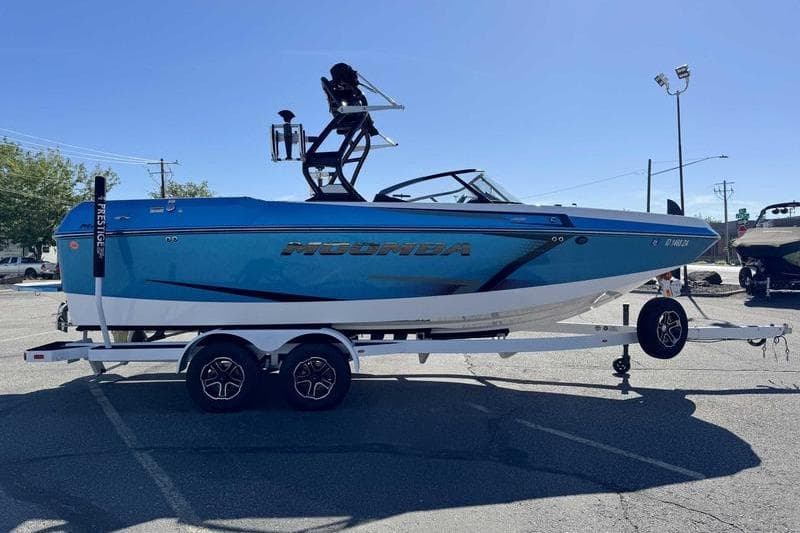 2021 Moomba Max boat on trailer in parking lot, side view.