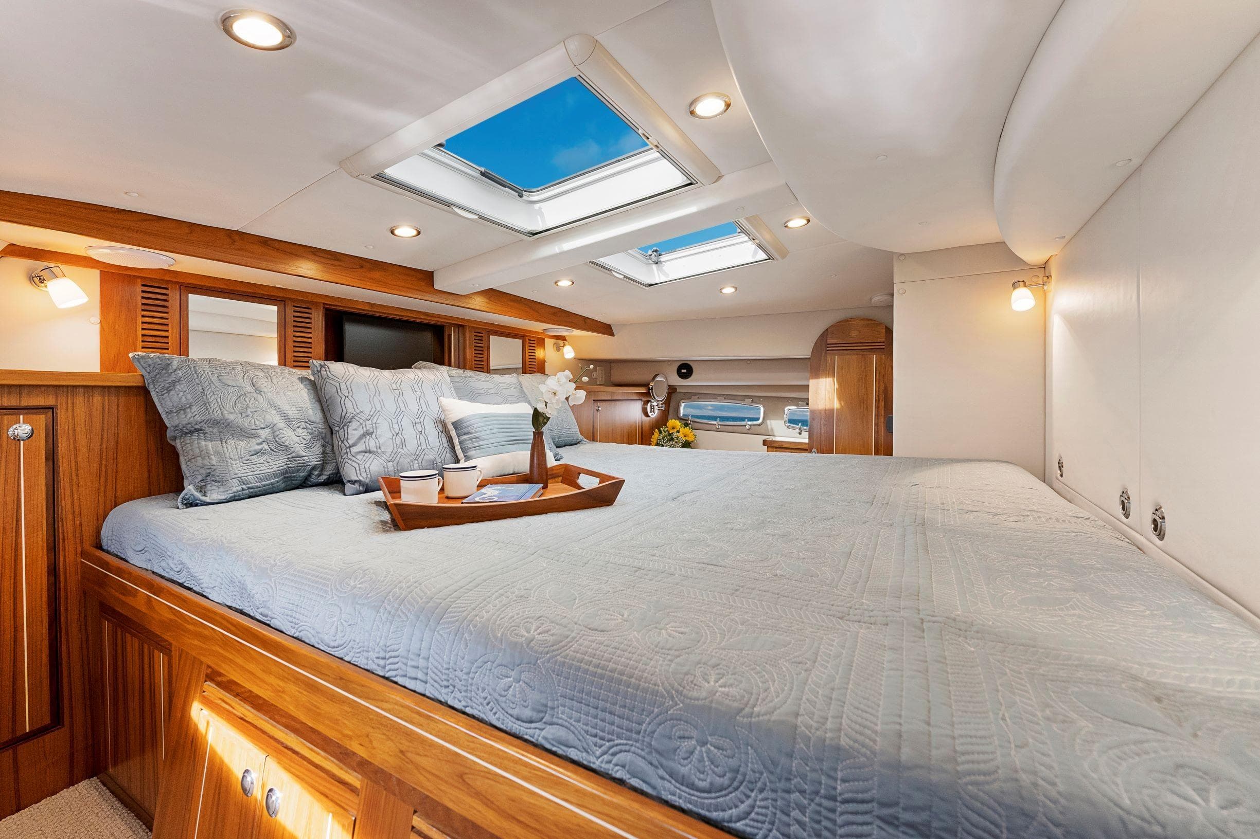 Luxurious bedroom interior of 2026 Aspen C120 Flybridge yacht with skylights and elegant bedding.