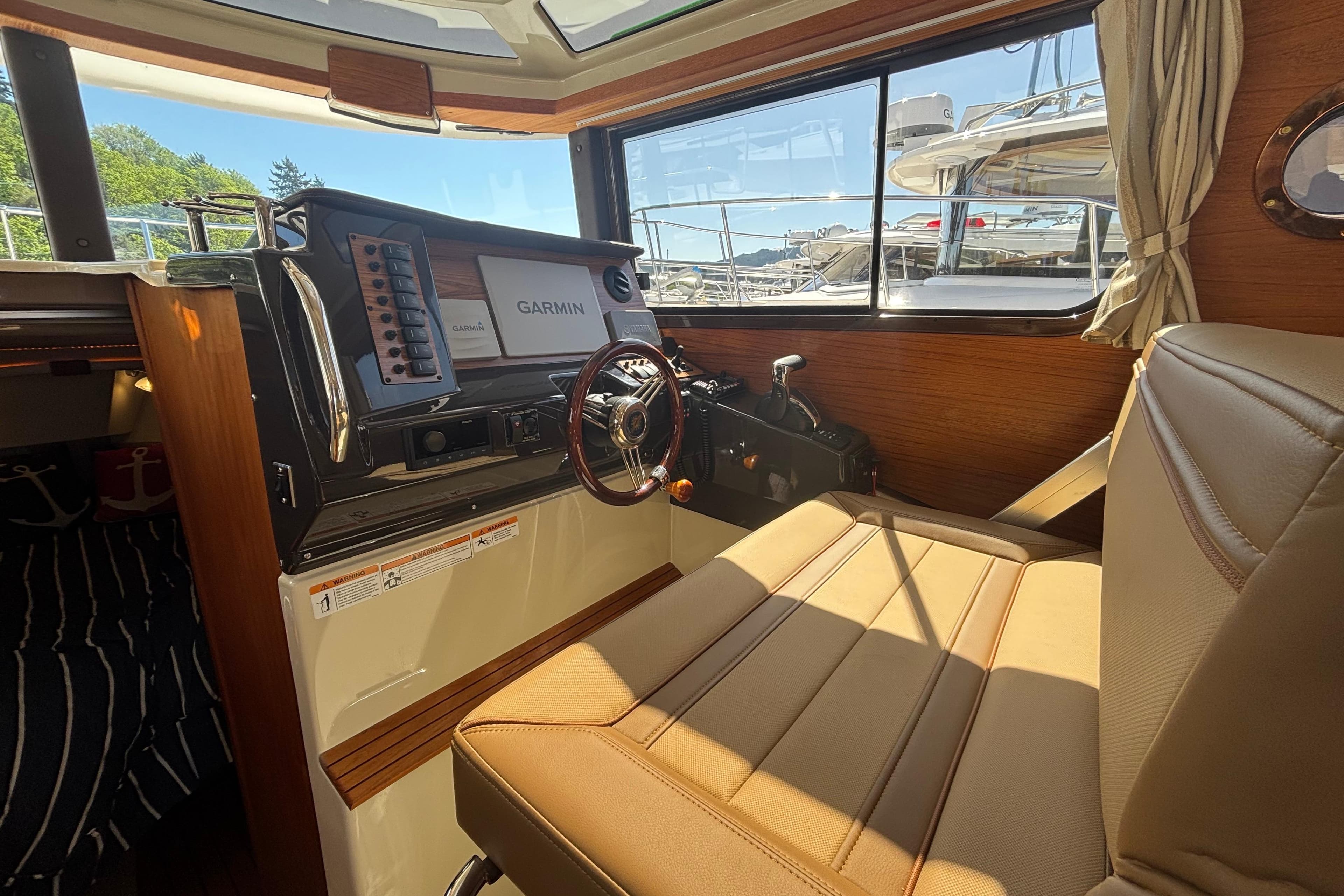 Interior of 2022 Ranger Tugs R-27 boat with Garmin navigation system and leather seating.