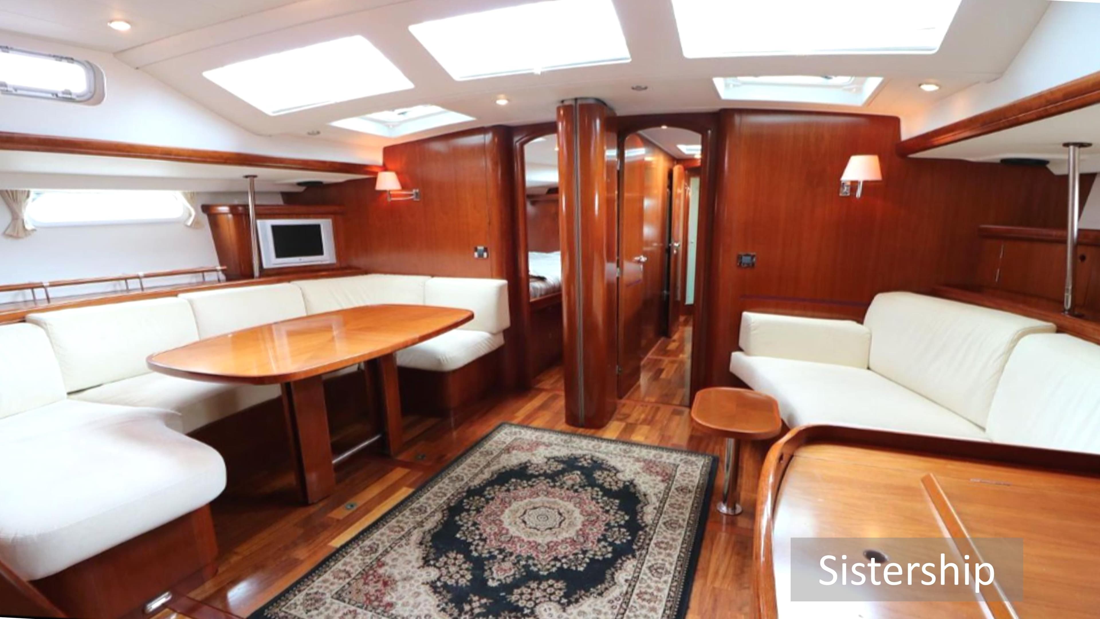 Luxurious interior of a 2005 Beneteau 57 yacht with elegant wood finishes and plush seating.
