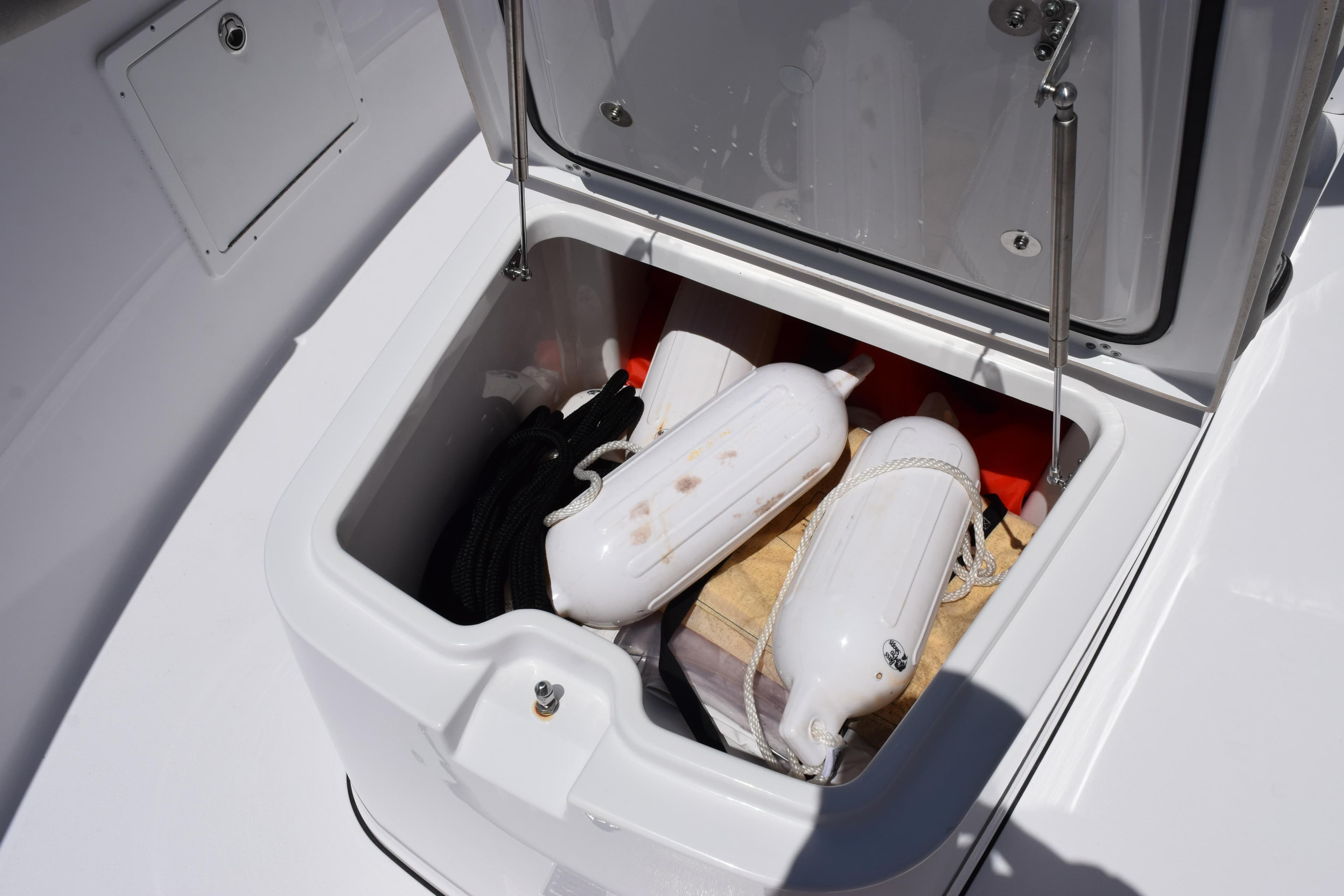 Storage compartment on 2022 Sportsman Open 282TE Center Console with boat fenders and ropes.