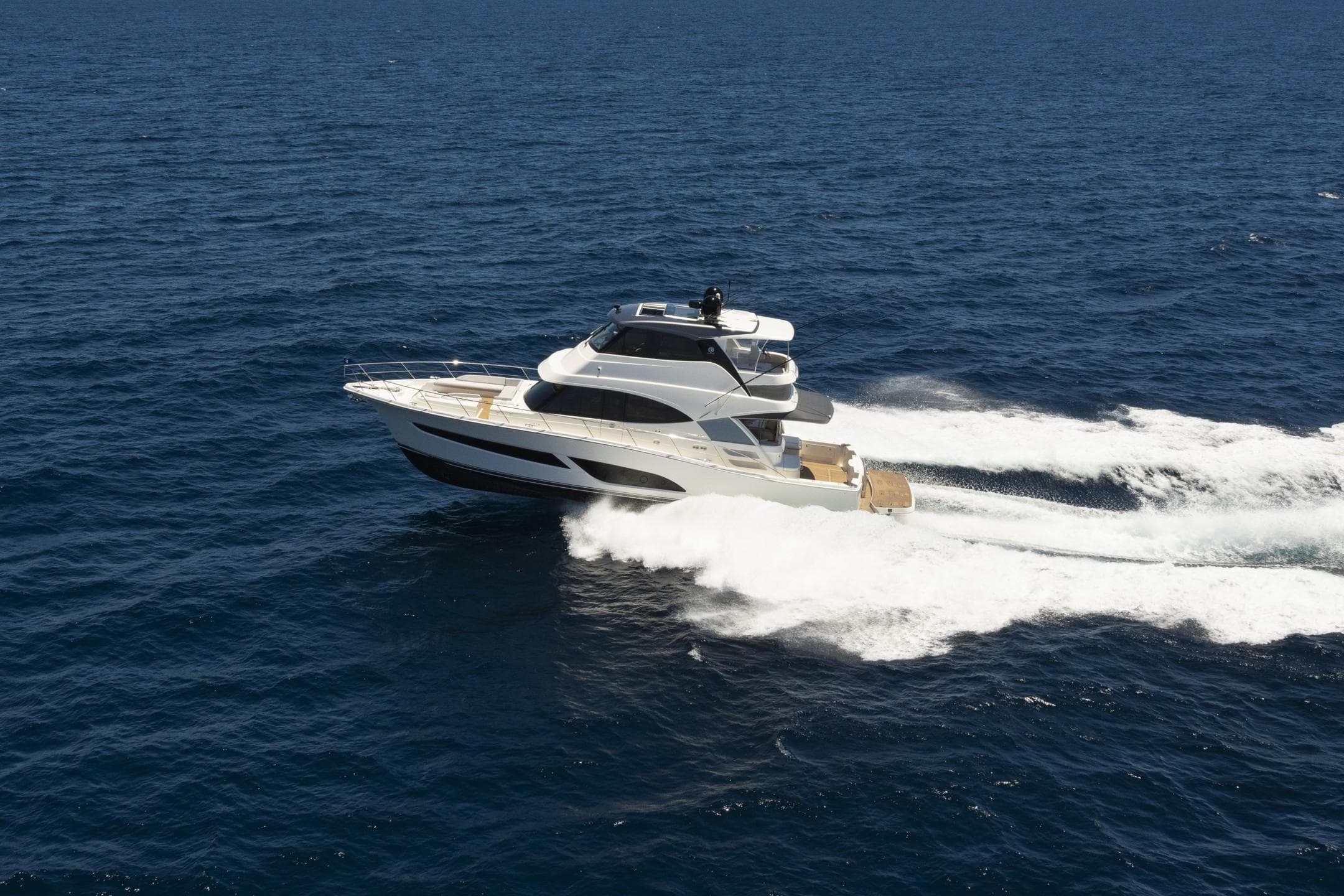 2025 Riviera 58 Sports Motor Yacht cruising on open sea, showcasing sleek design and performance.