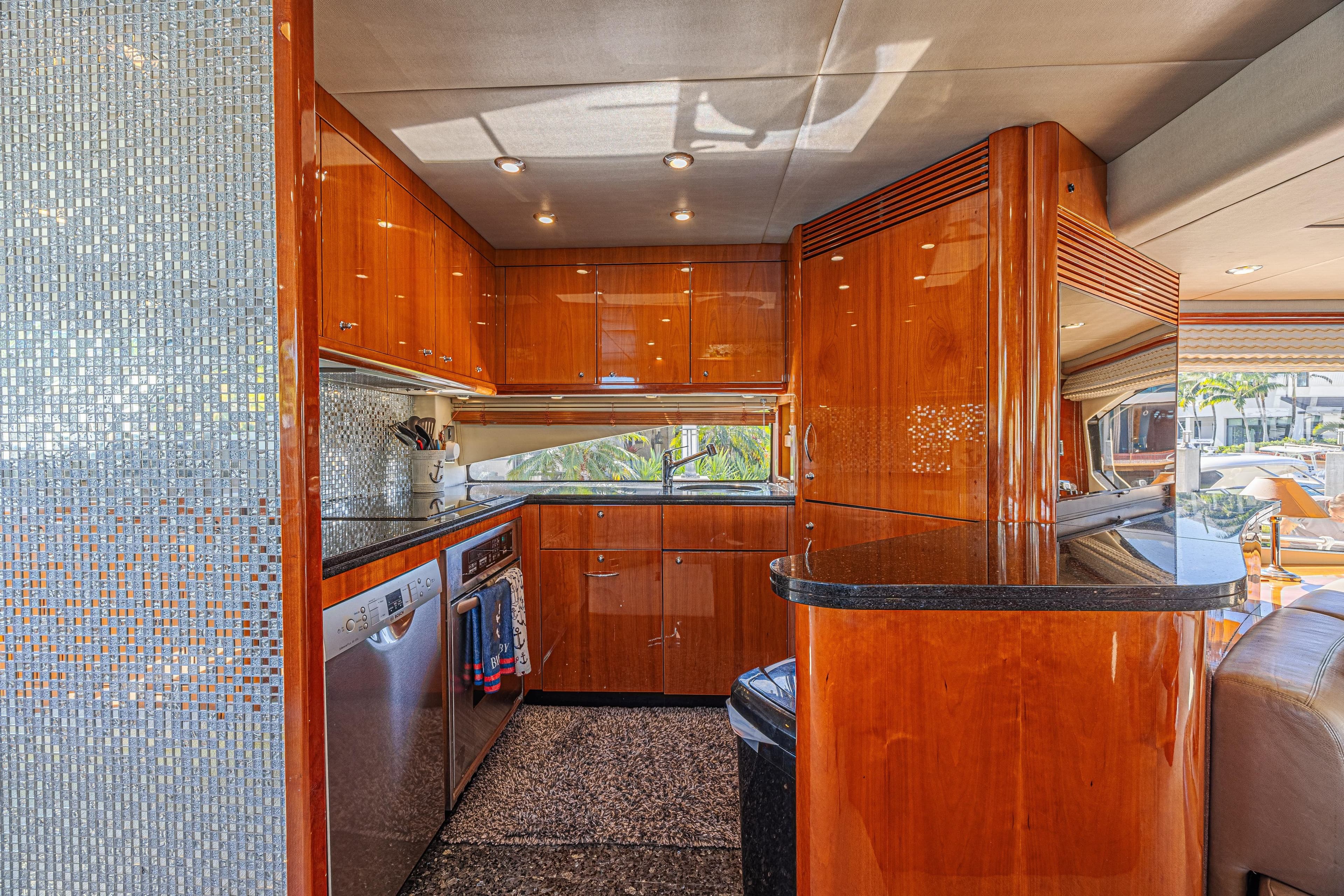 Luxurious kitchen interior of 2006 Sunseeker 75 Yacht with glossy wood finish.