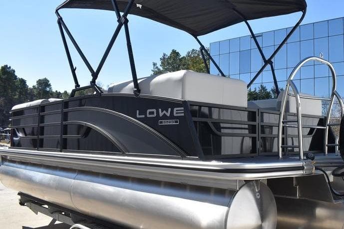 2026 Lowe SS 230 pontoon boat with canopy, docked outdoors.