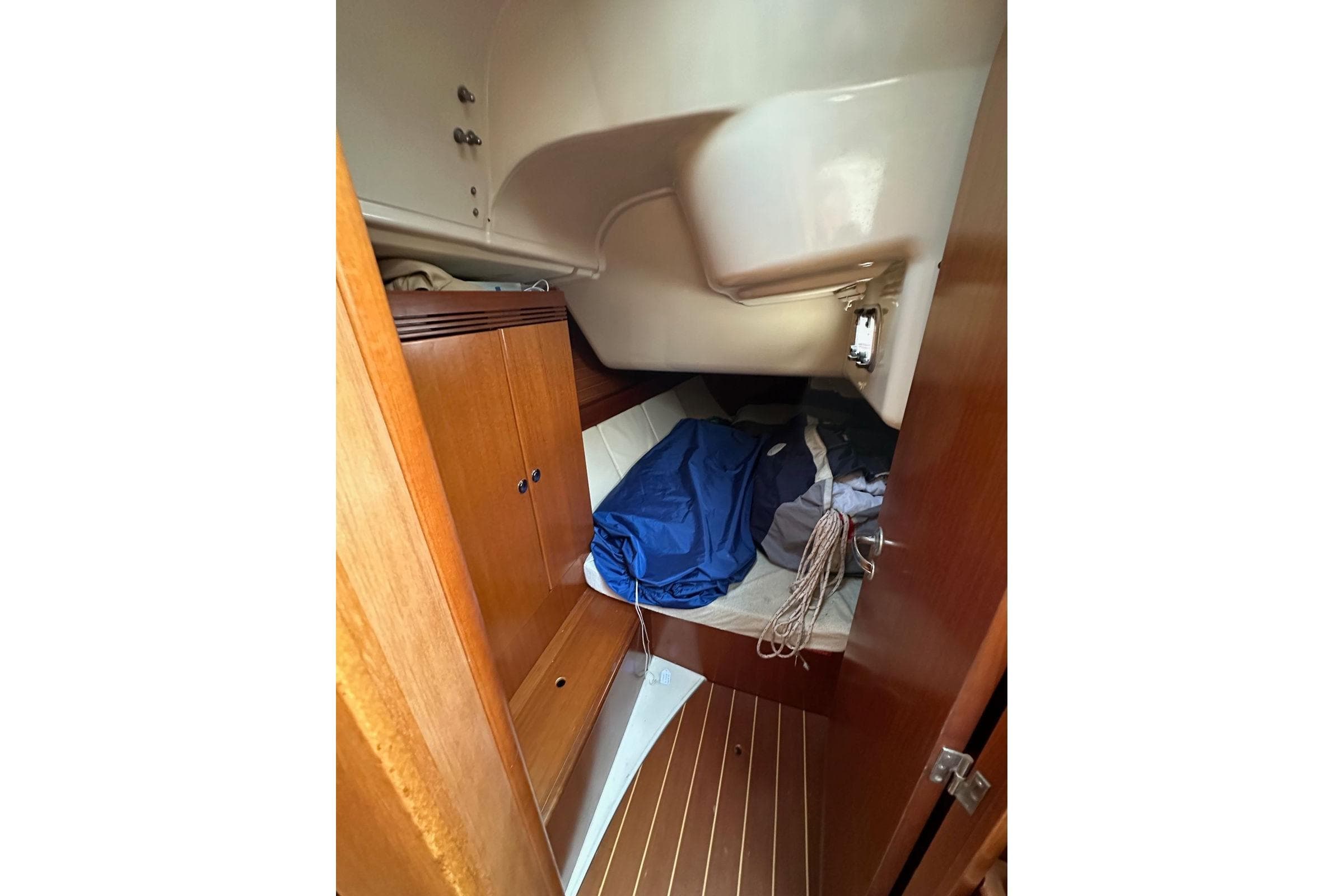 Cabin interior of 2004 Dufour 40 sailboat with wooden cabinetry and cozy sleeping area.