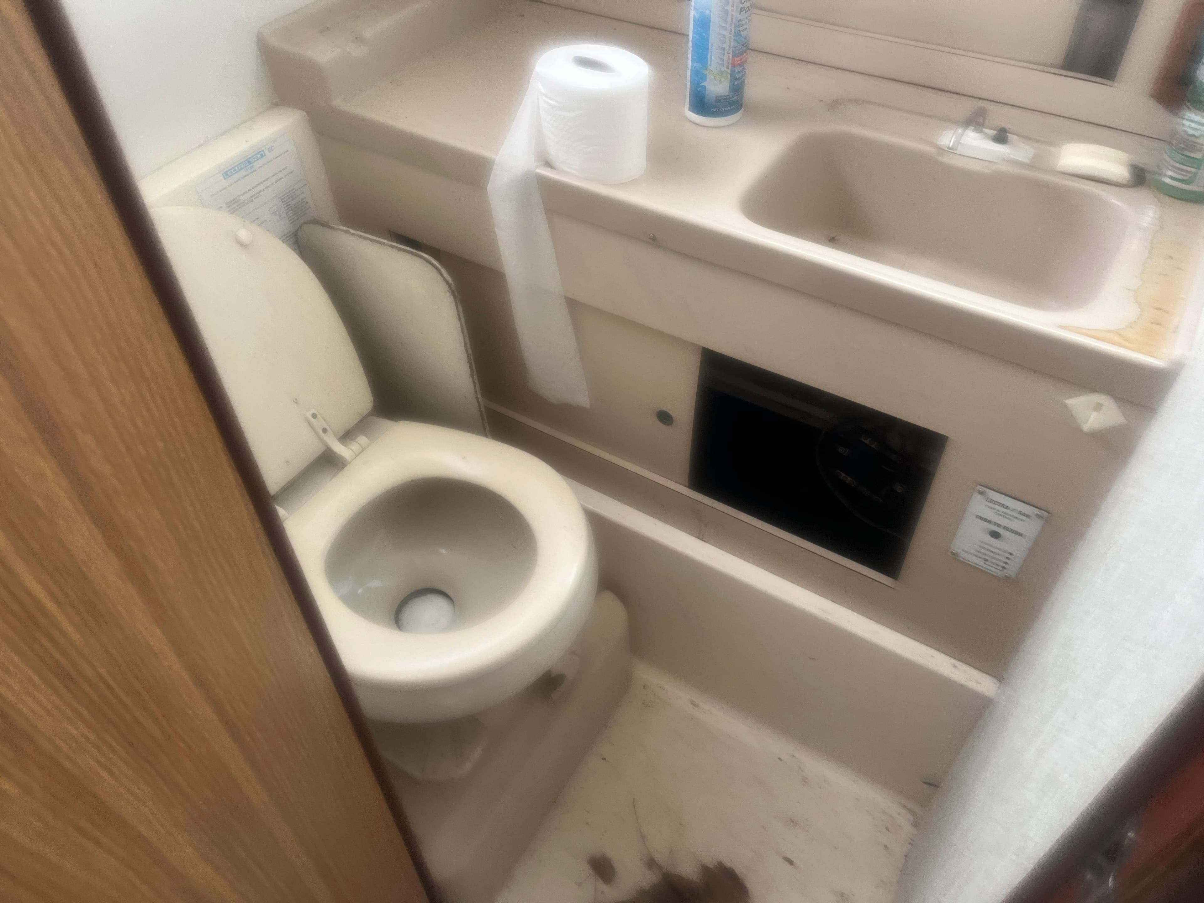 1973 Bertram 28 Flybridge Cruiser bathroom with toilet, sink, and toiletries.