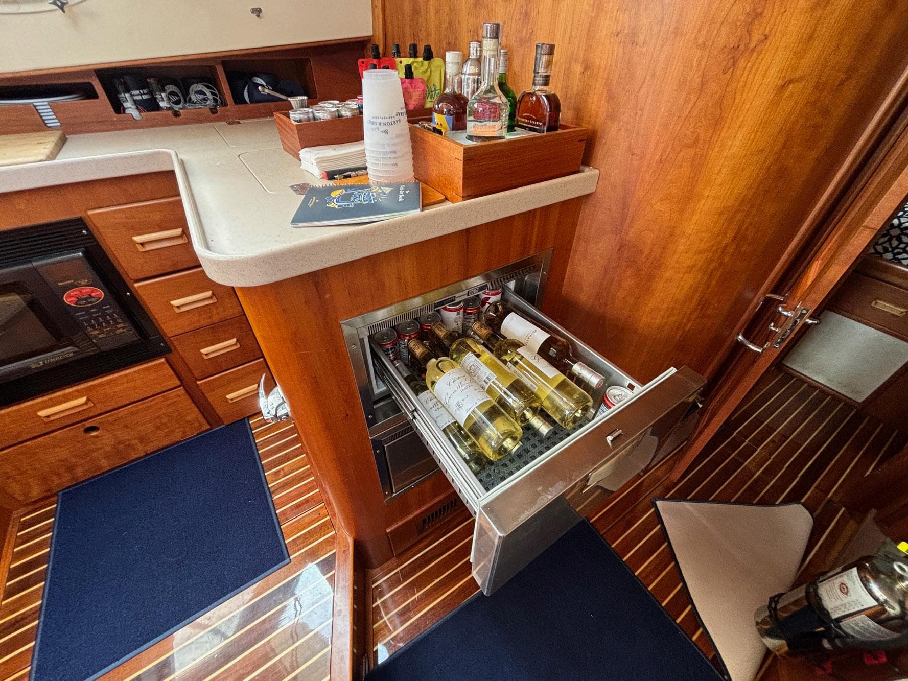 Hinckley Talaria 44 MY 2005 yacht interior with open wine drawer and wooden cabinetry.