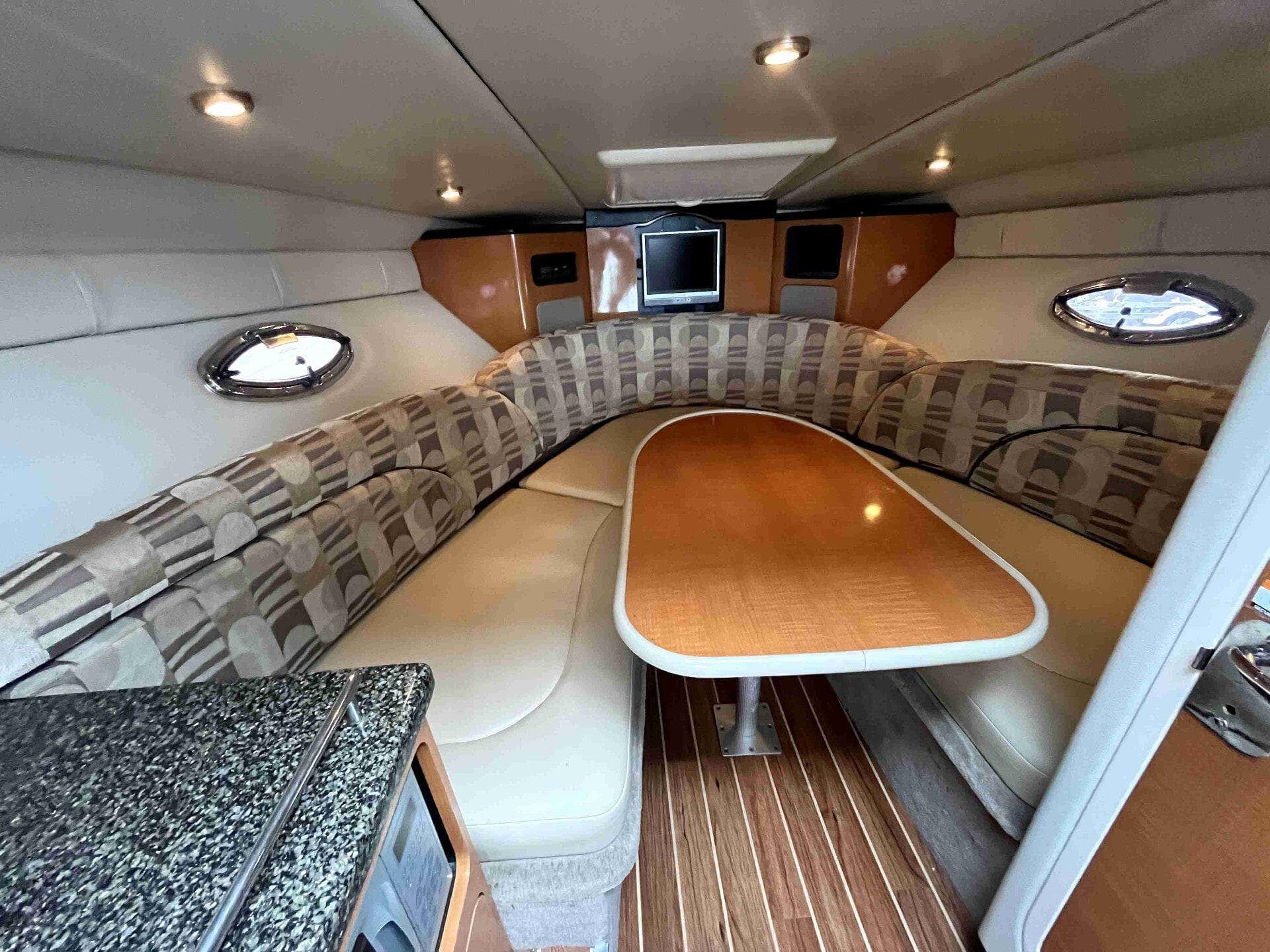 2007 Chaparral 275 SSi boat interior with cozy seating and wooden table.